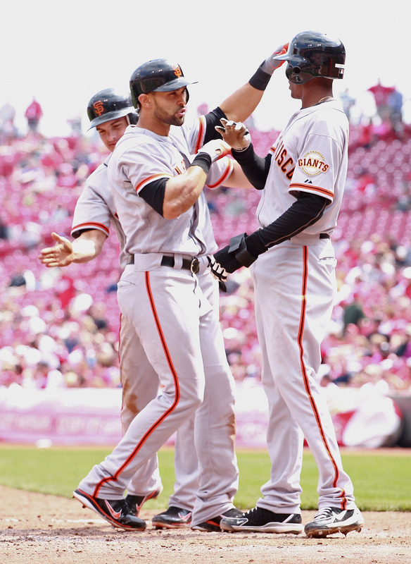  Angel Pagan #16 (center) Of The San Francisco Giants Is Congratulated By Ryan Theriot #5 (left)and Joaquin Arias #13 (