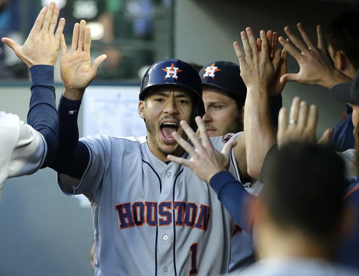 Carlos Correa is greeted after scoring from second base on a wild pitch. (AP)