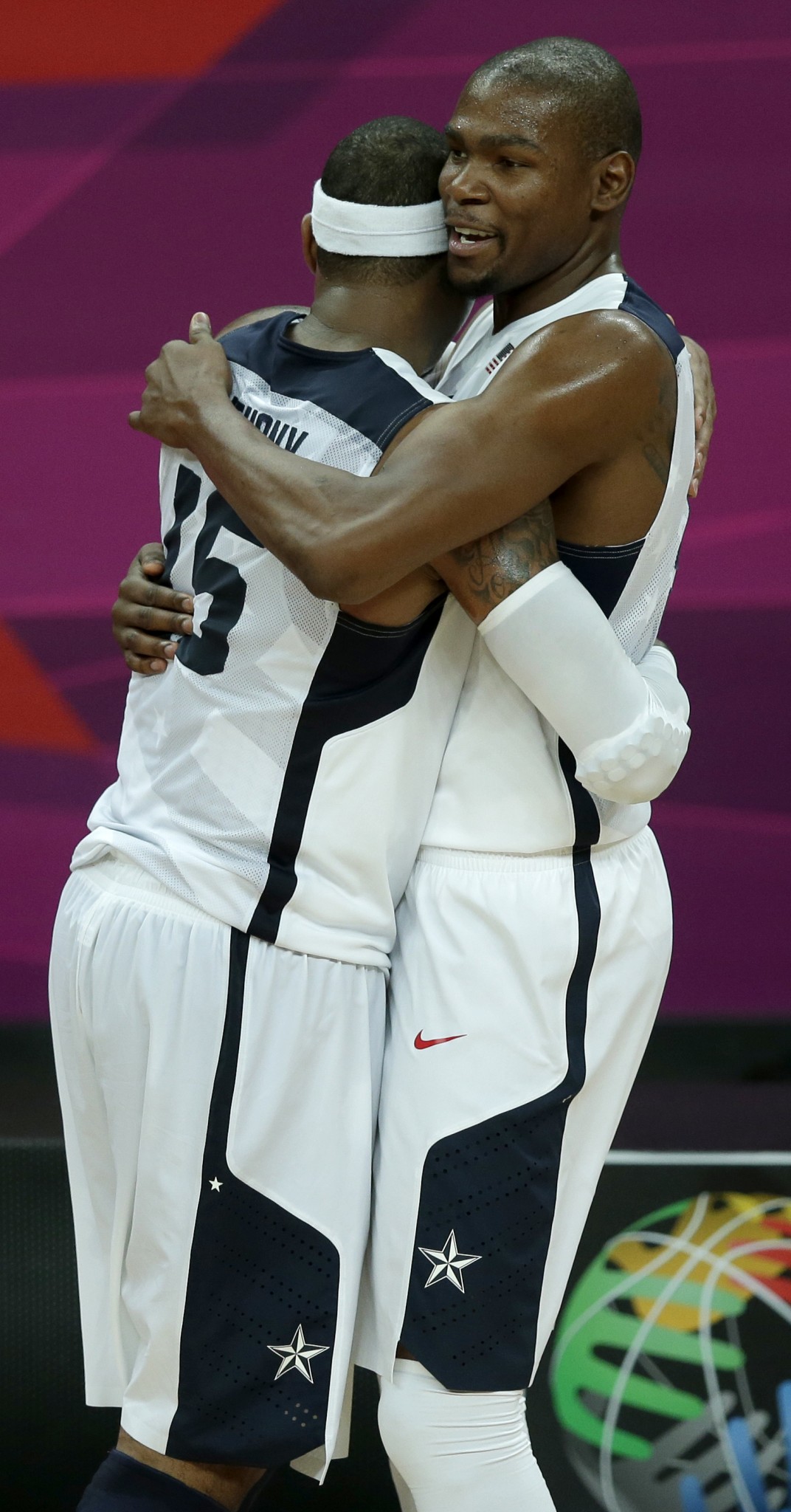 Kevin Durant accepts the hug of U.S. teammate Carmelo Anthony in 2012. (AP/Charlie Riedel)
