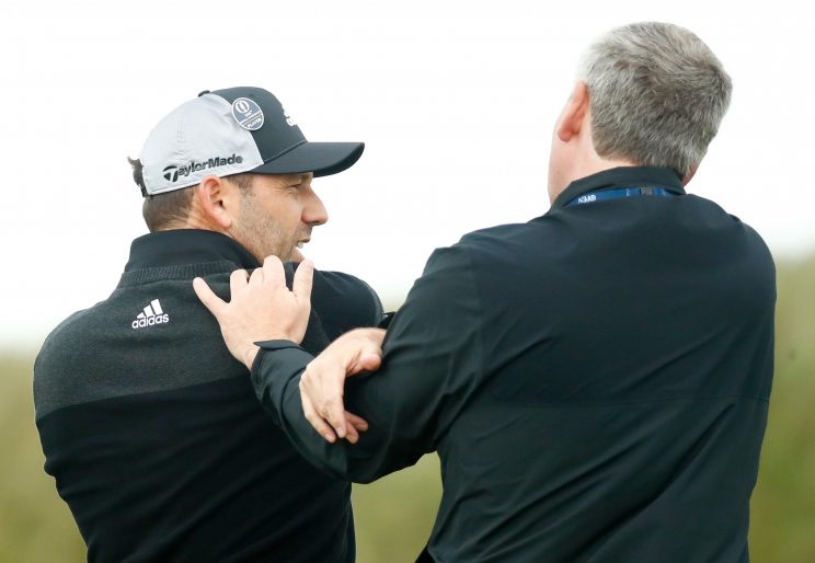 Sergio Garcia gets medical attention after slamming his club on Friday. (Getty Images)