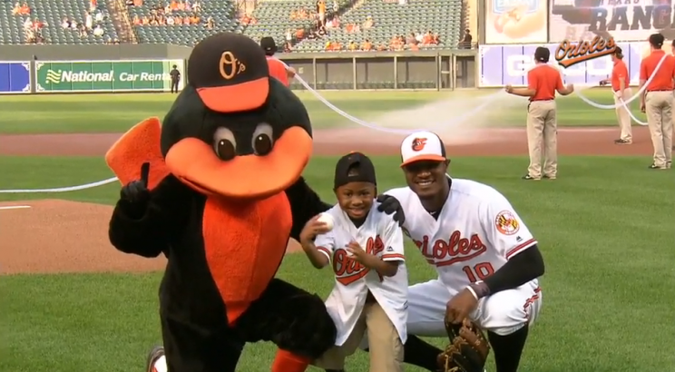 Zion poses with Adam Jones and the Orioles mascot after throwing the first pitch at the Orioles-Rangers game on August 2, 2016.