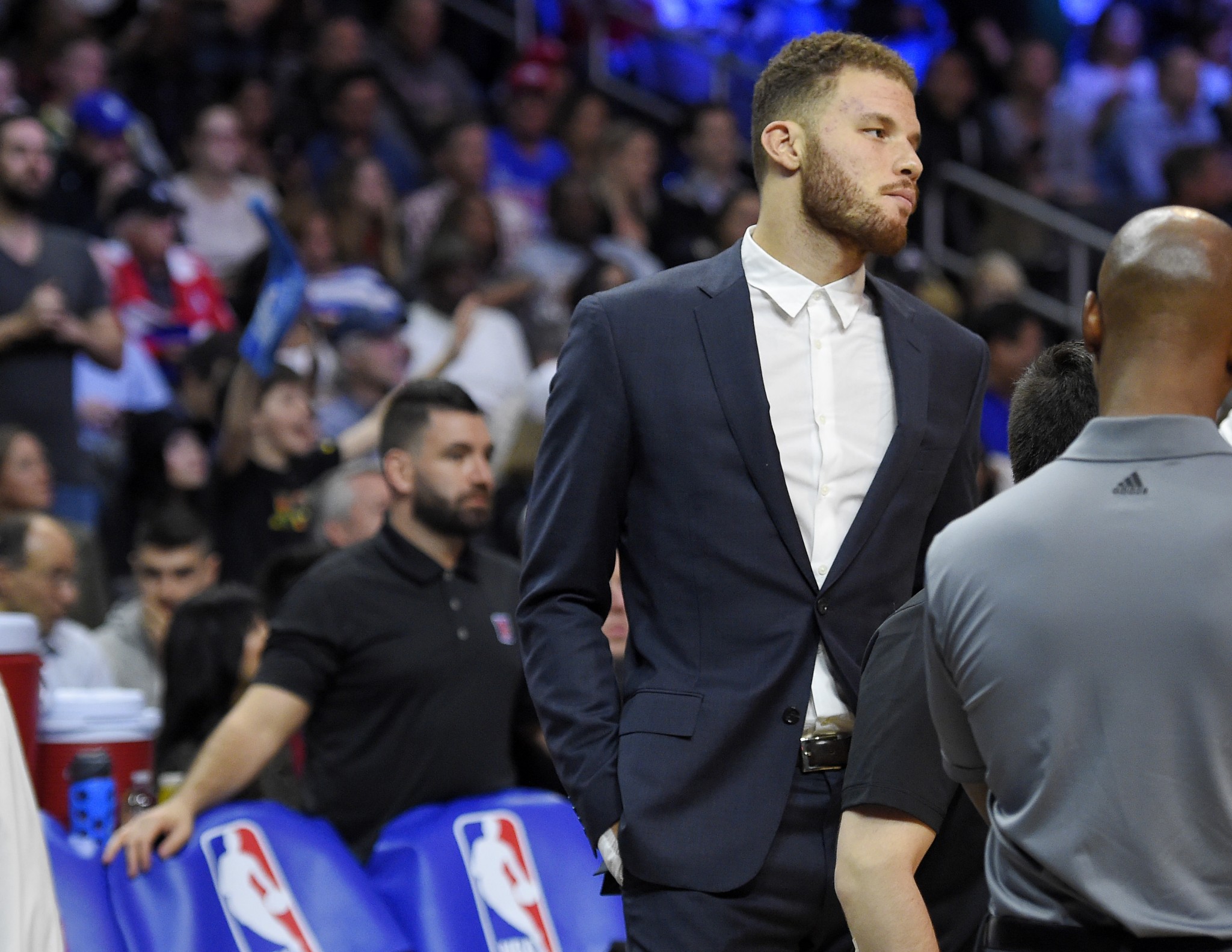 Blake Griffin stands on the court as Clippers equipment manager Matias Testi (left) stands behind the bench during a Feb. 18, 2016, game. (AP/Mark J. Terrill)