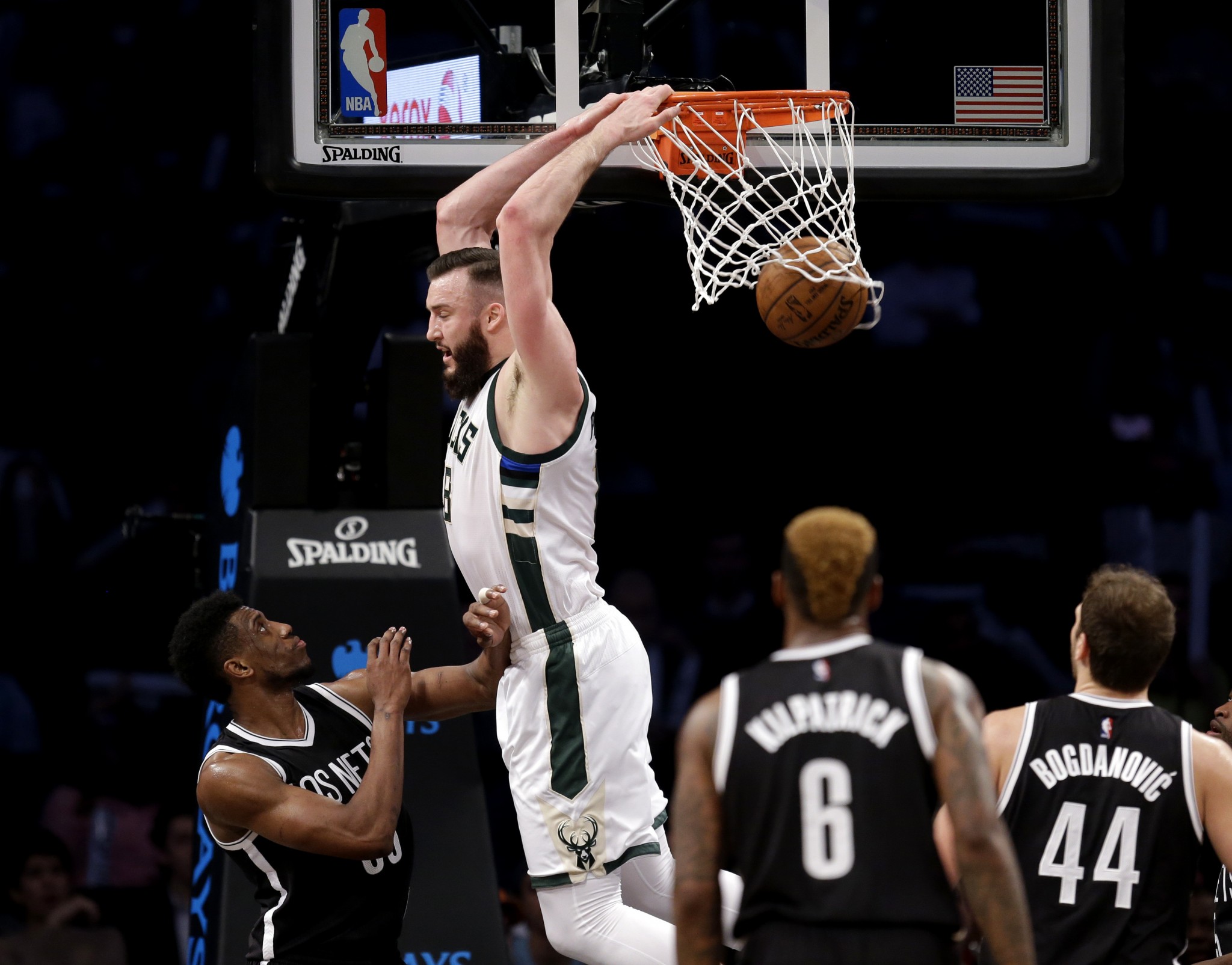 Miles Plumlee throws down a reverse dunk in front of Thaddeus Young during a March 2016 Bucks-Nets game. (AP/Seth Wenig)