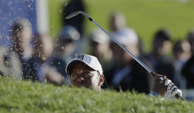 Tiger Woods hits out of a bunker on the 17th hole. (AP)