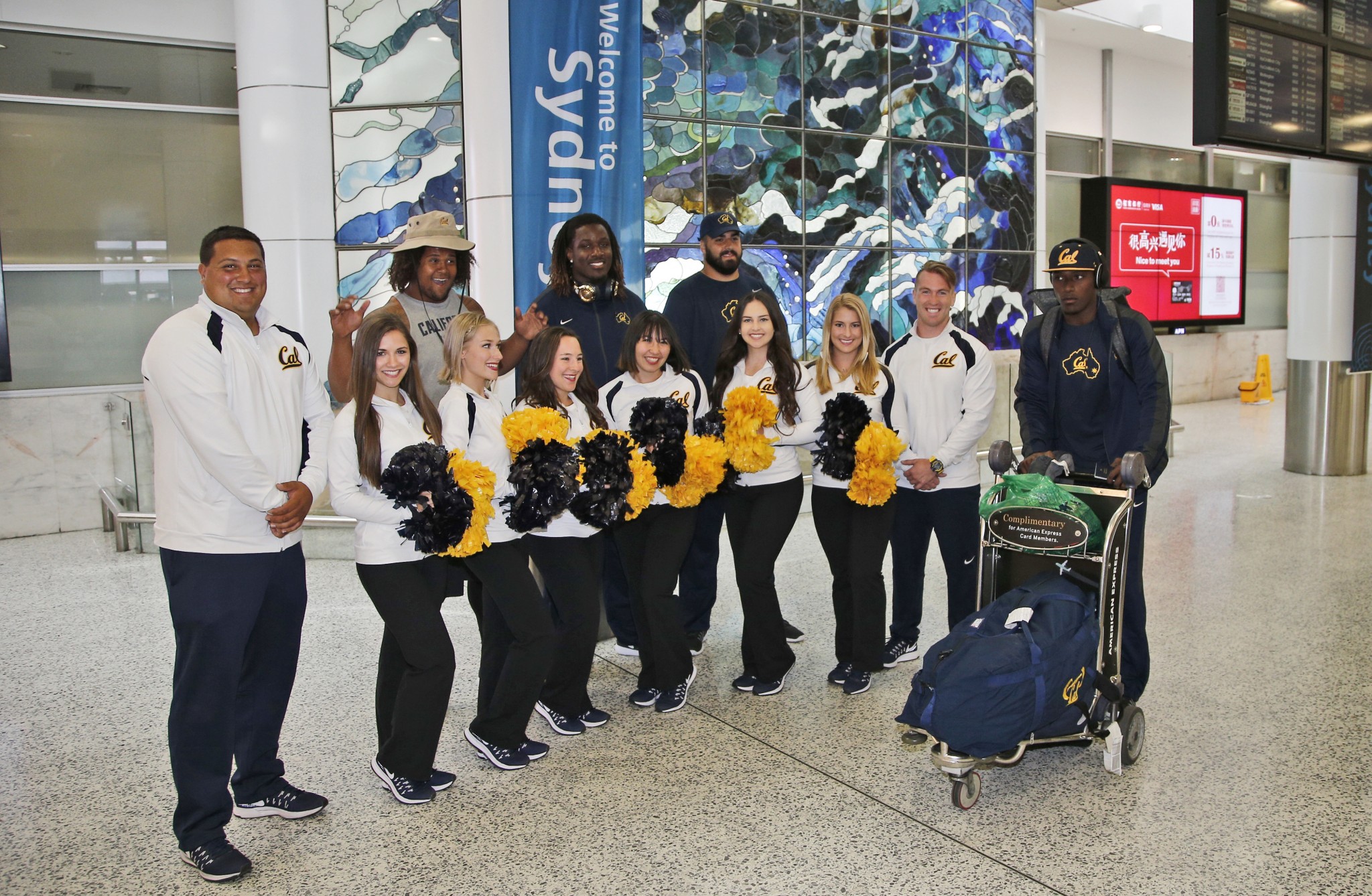 California Golden Bears cheerleaders welcome players as they arrive at Sydney International airport. (AP Photo/Rob Griffith)