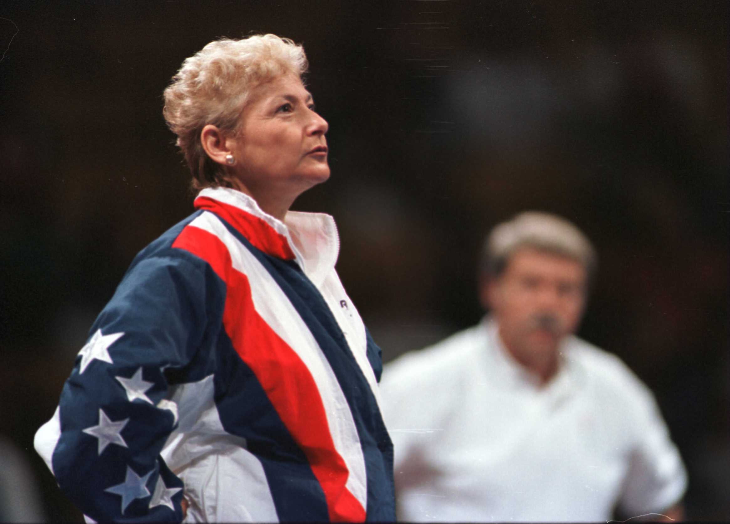 Then-coach Marta Karolyi watches warmups prior to the 1996 Olympic Trials with her husband, Bela, in the background. (Getty)