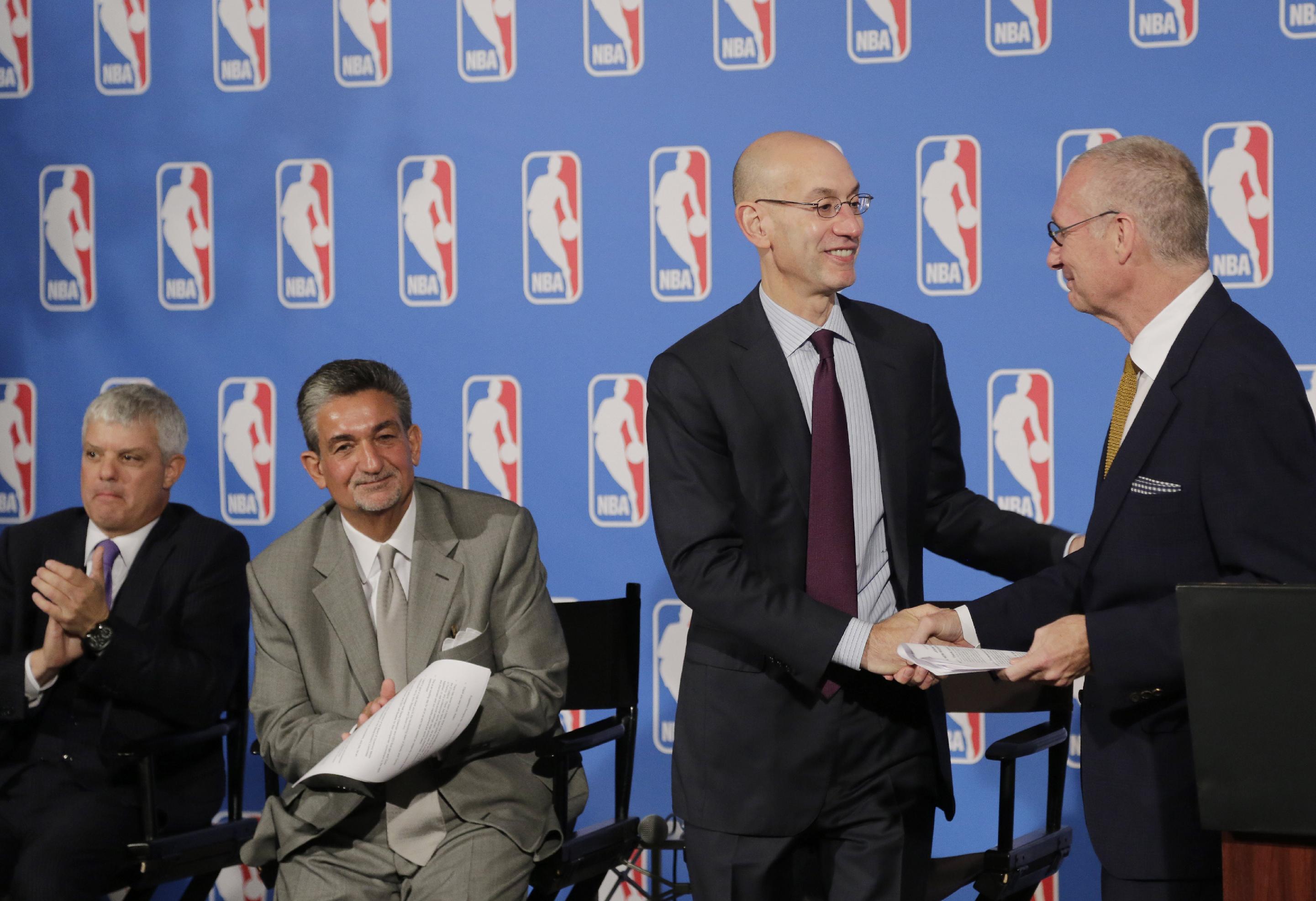ESPN President John Skipper (right) and Commissioner Adam Silver shake on the new TV deal. (AP/Mark Lennihan)