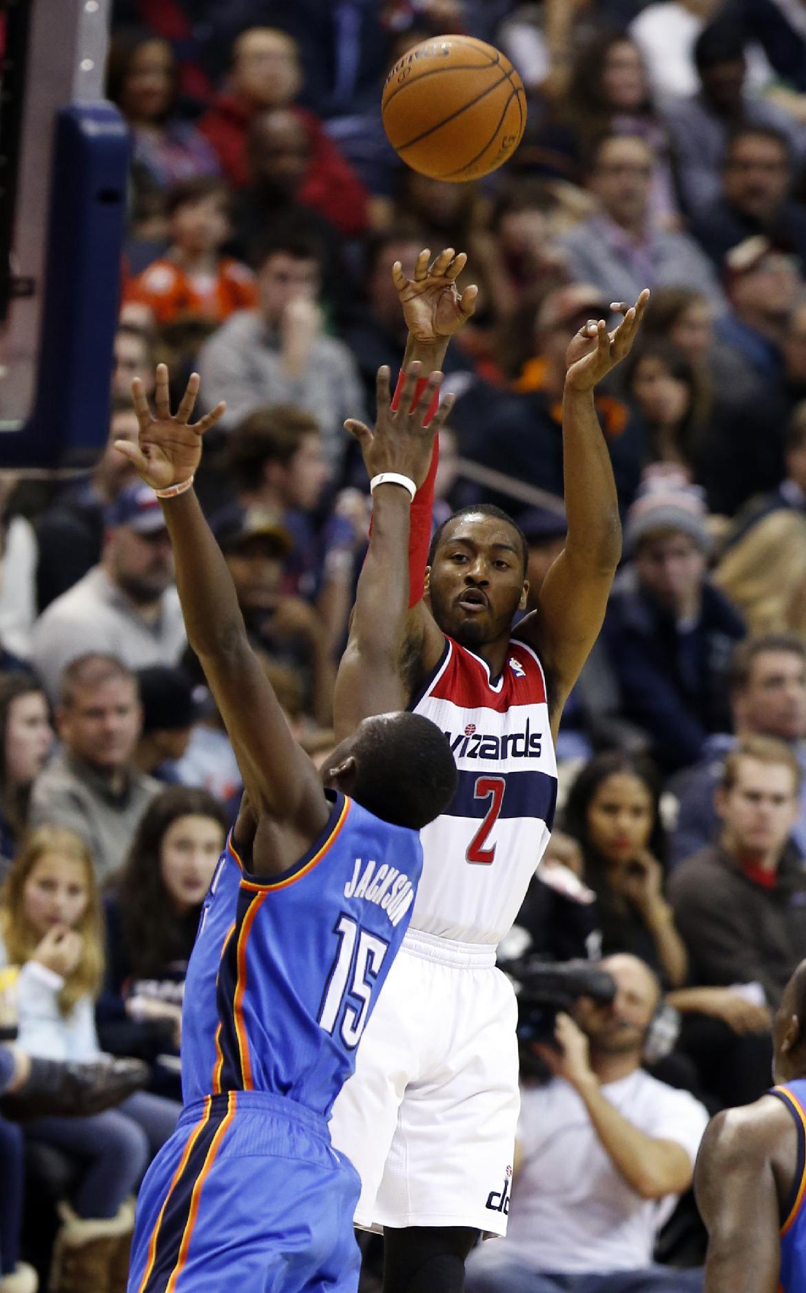 Washington Wizards guard John Wall (2) shoots over Oklahoma City Thunder guard Reggie Jackson (15) in the second half of an NBA basketball game on Saturday, Feb. 1, 2014, in Washington. Wall had 17 points and the Wizards won 96-81. (AP Photo/Alex Brandon)