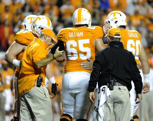 Tennessee left tackle Jacob Gilliam is helped off the field after sustaining a knee injury against Utah State. (AP Photo, Michael Patrick/Knoxville News Sentinel)