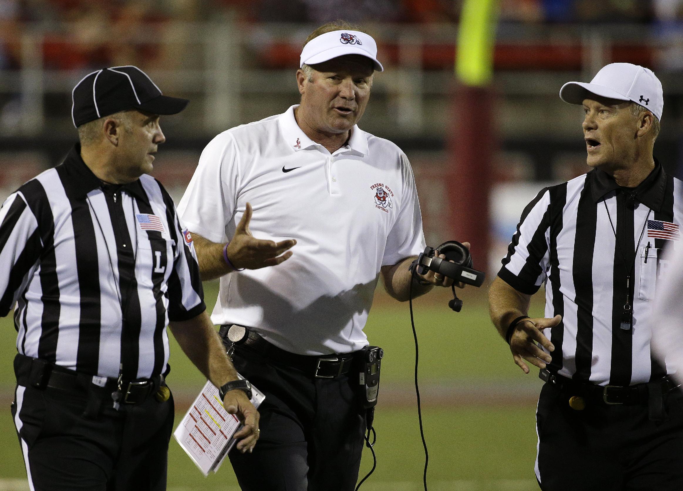 Fresno State Bulldogs head coach Tim DeRuyter speaks with officials during the first half of an NCAA college football game against the UNLV Rebels Friday, Oct. 10, 2014, in Las Vegas. (AP Photo/John Locher)