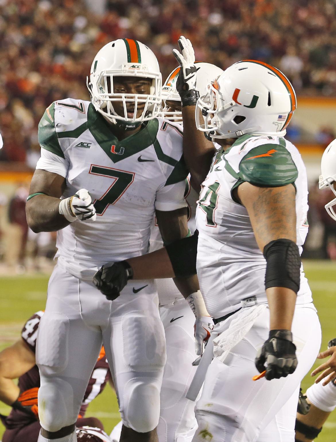 Miami running back Gus Edwards (7) celebrates a touchdown with offensive lineman Ereck Flowers, right, during the first half against Virginia Tech. (AP Photo/Steve Helber)