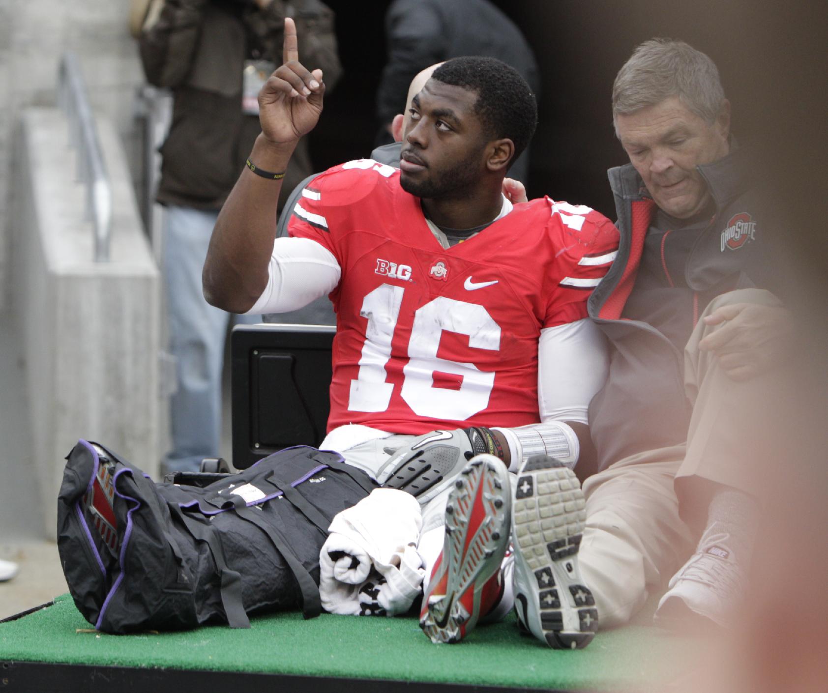 Ohio State quarterback J.T. Barrett acknowledges fans as he is driven from the field after an injury in the fourth quarter of an NCAA college football game Saturday, Nov. 29, 2014, in Columbus, Ohio. Ohio State beat Michigan 42-28. (AP Photo/Jay LaPrete)