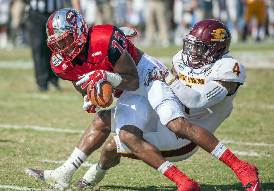 Western Kentucky wide receiver Antwane Grant stretches into the endzone for a touchdown despite the defensive effort from Central Michigan defensive back Brandon Greer during the Bahamas Bowl NCAA college football game, Wednesday, Dec. 24, 2014, in Nassau, Bahamas. (AP Photo/The Daily News, Austin Anthony)
