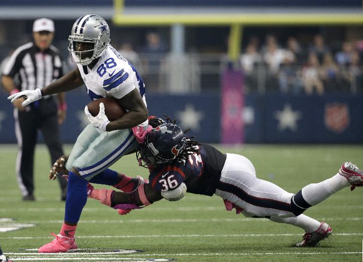 Houston Texans strong safety D.J. Swearinger (36) tries to wrap up Dallas Cowboys wide receiver Dez Bryant (88), Sunday, Oct. 5, 2014, in Arlington, Texas. (AP Photo/Tim Sharp)