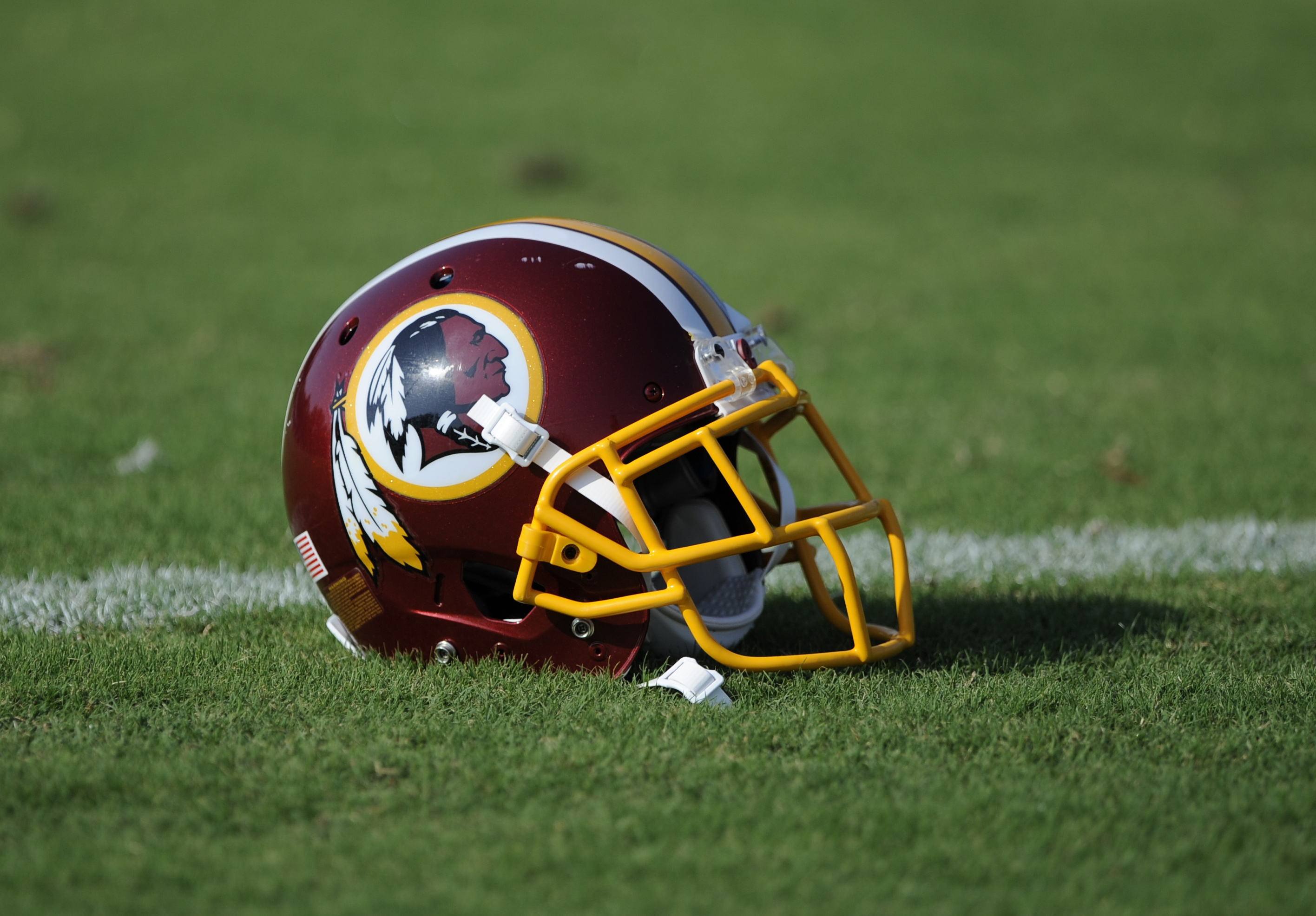 A Washington Redskins football helmet lies on the field during NFL football minicamp, Wednesday, June 18, 2014, in Ashburn, Va. The U.S. Patent Office ruled Wednesday, June 18, 2014, that the Washington Redskins nickname is 