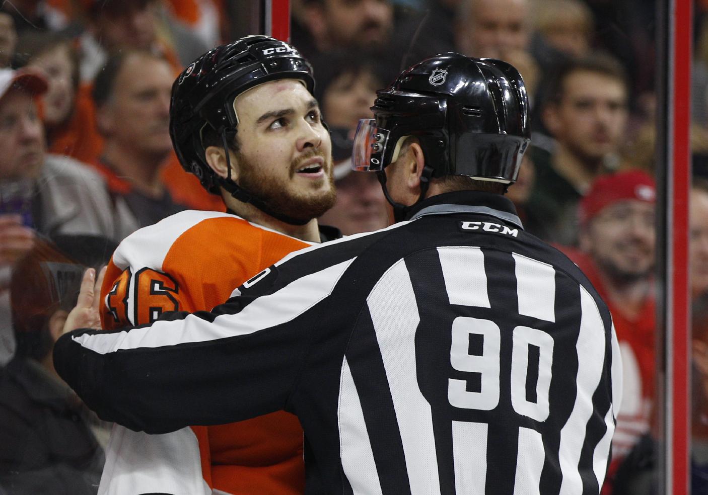 Philadelphia Flyers center Zac Rinaldo looks up as he is being held back by linesman Andy McElman and will be charged with a 10 minute game misconduct penalty during the third period of an NHL hockey game against the Vancouver Canucks, Thursday, Jan. 15, 2015, in Philadelphia. The Canucks won 4-0. (AP Photo/Chris Szagola)