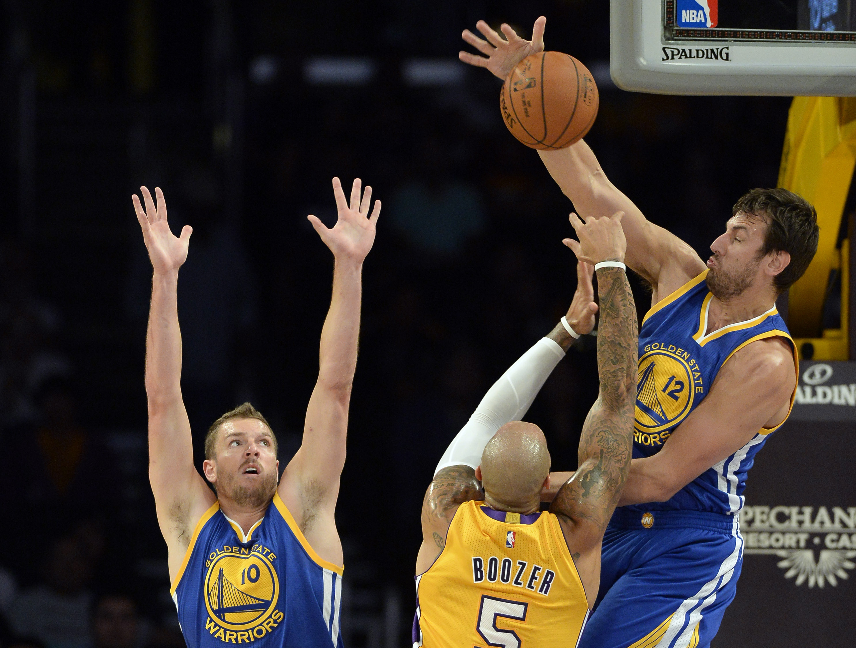 Oct 9, 2014; Los Angeles, CA, USA; Golden State Warriors center Andrew Bogut (12) blocks the shot of Los Angeles Lakers forward Carlos Boozer (5) during the first half at Staples Center. (Richard Mackson-USA TODAY Sports)