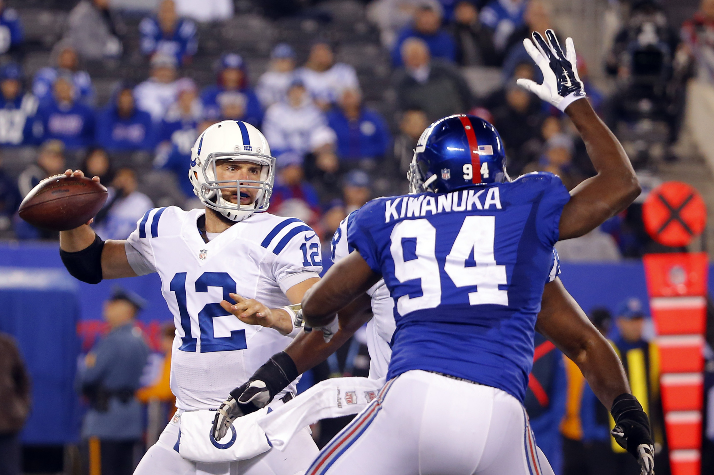 Nov 3, 2014; East Rutherford, NJ, USA; Indianapolis Colts quarterback Andrew Luck (12) gets a pass off as he is pressured by New York Giants defensive end Mathias Kiwanuka (94) at MetLife Stadium. Indianapolis Colts defeat the New York Giants 40-24. (Jim O'Connor-USA TODAY Sports)