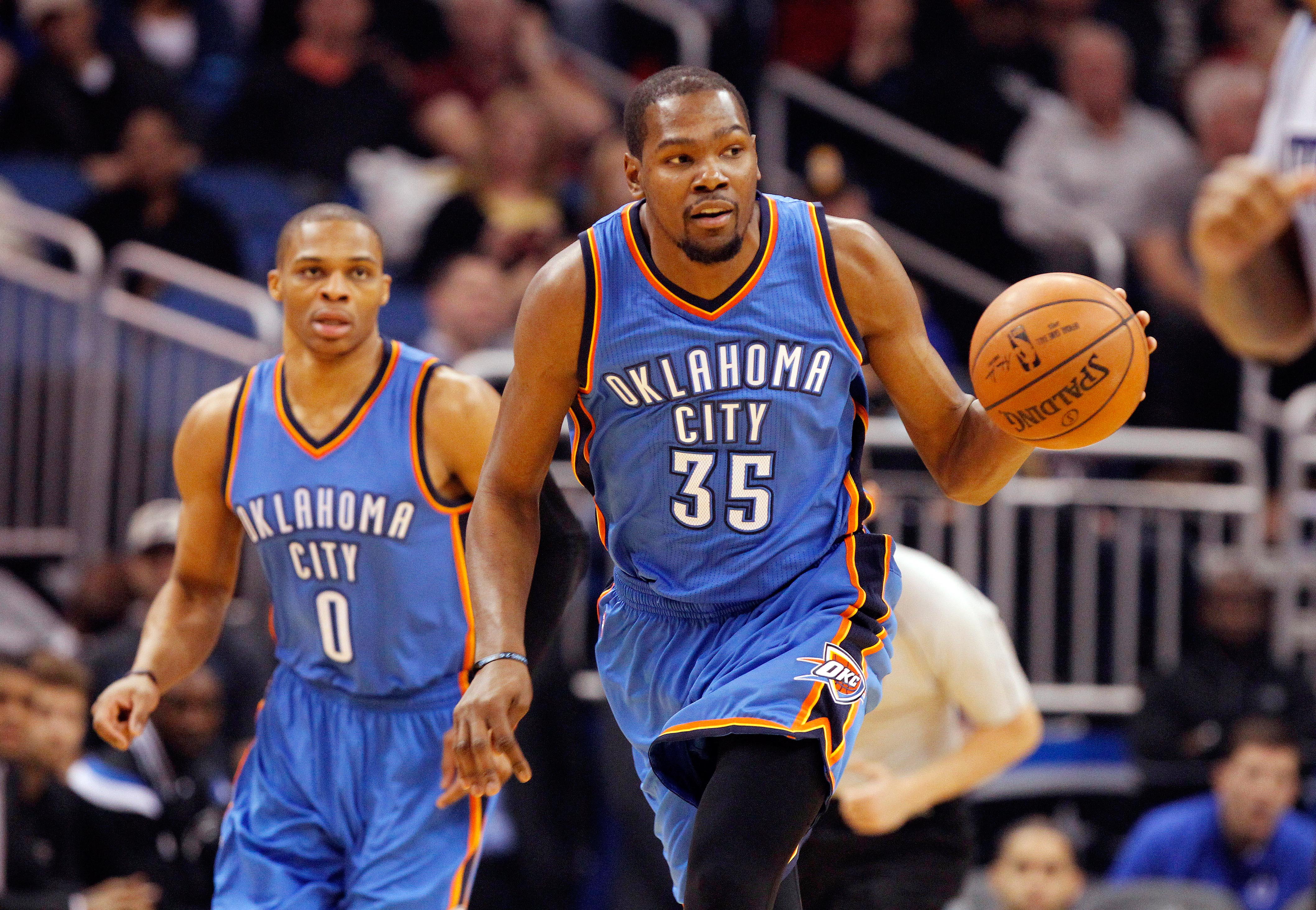 Jan 18, 2015; Orlando, FL, USA; Oklahoma City Thunder forward Kevin Durant (35) dribbles the ball as guard Russell Westbrook (0) runs behind during the first quarter against the Orlando Magic at Amway Center. (Kim Klement-USA TODAY Sports)