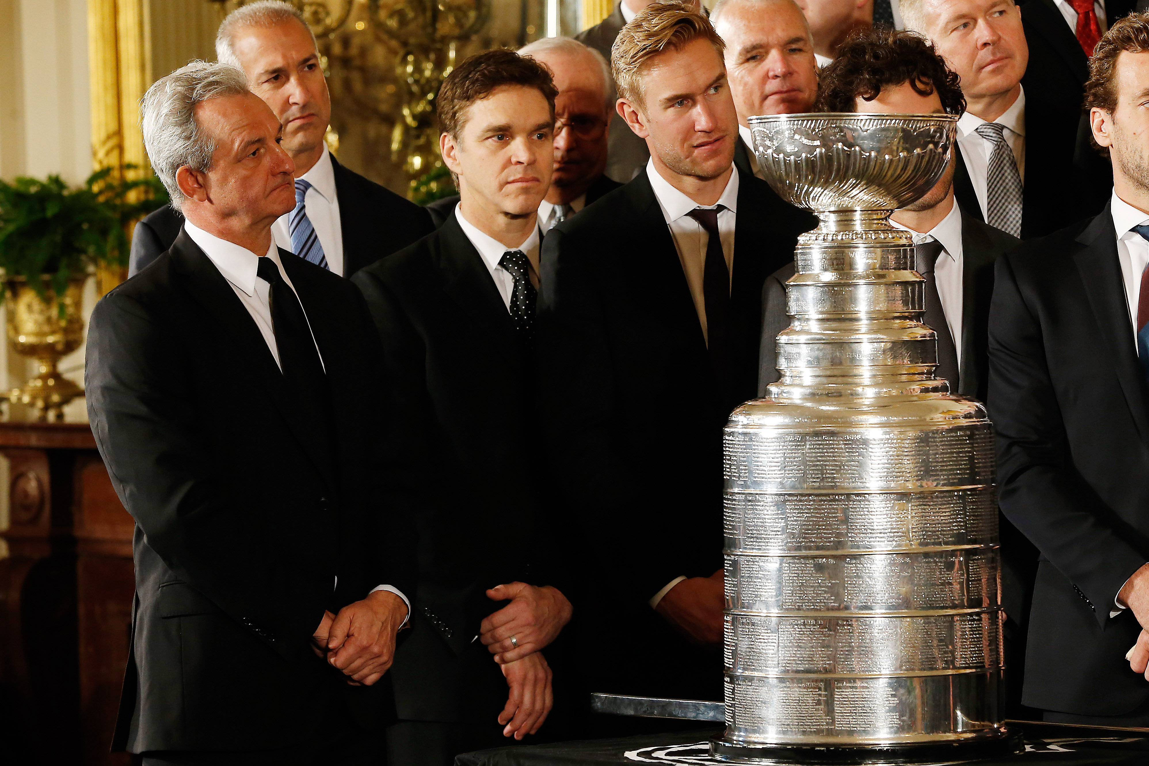 Feb 2, 2015; Washington, DC, USA; (L-R) Los Angeles Kings head coach Darryl Sutter, Kings president of business operations Luc Robitaille, and Kings center Jeff Carter listen while standing behind the Stanley Cup as President Barack Obama (not pictured) speaks at a ceremony honoring the NHL Stanley Cup Champion Kings and the MLS Champion Los Angeles Galaxy in the East Room at The White House. (Geoff Burke-USA TODAY Sports)