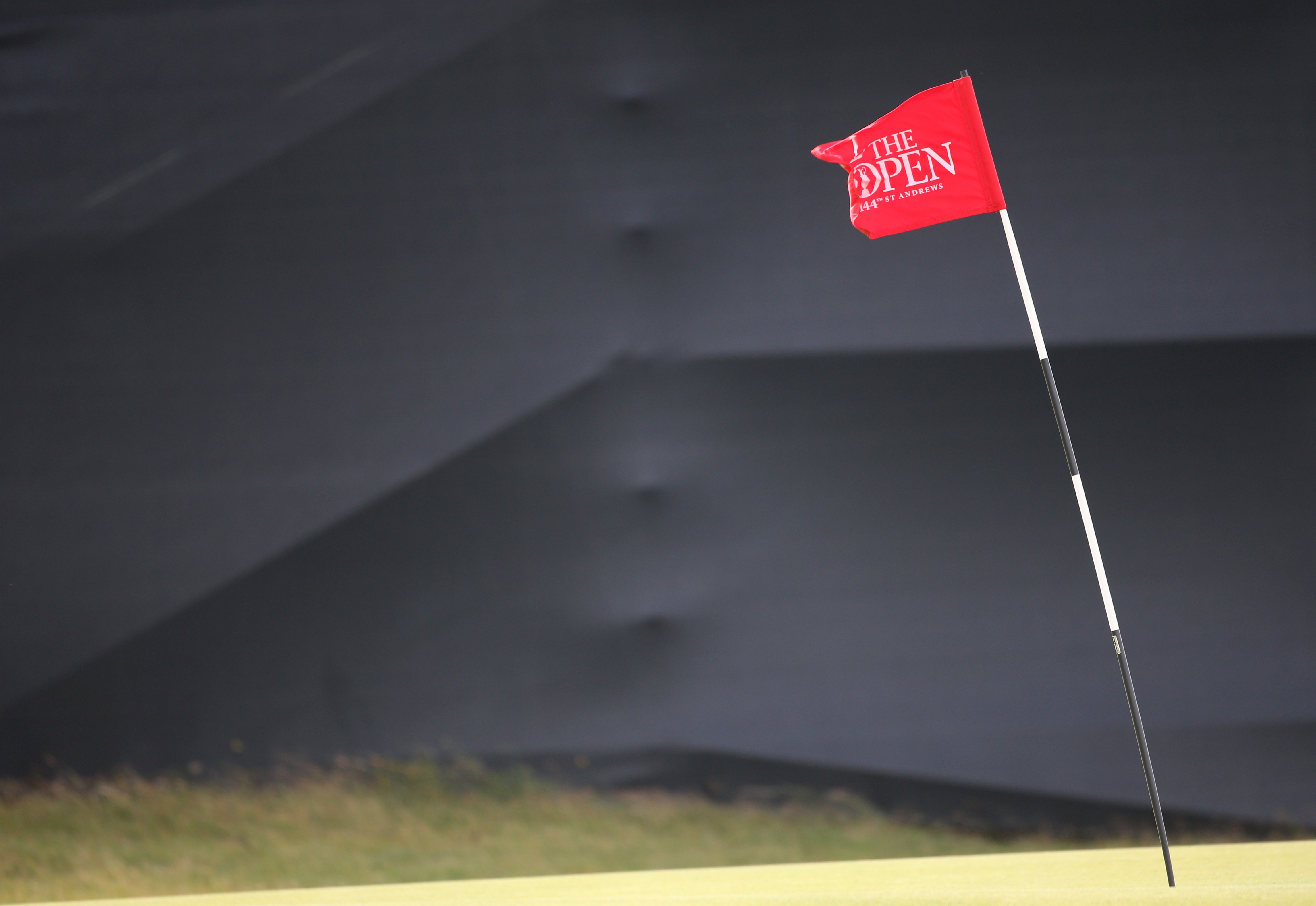A pin marker sways in the wind on the 12th green after high winds forced a suspension. (AP)