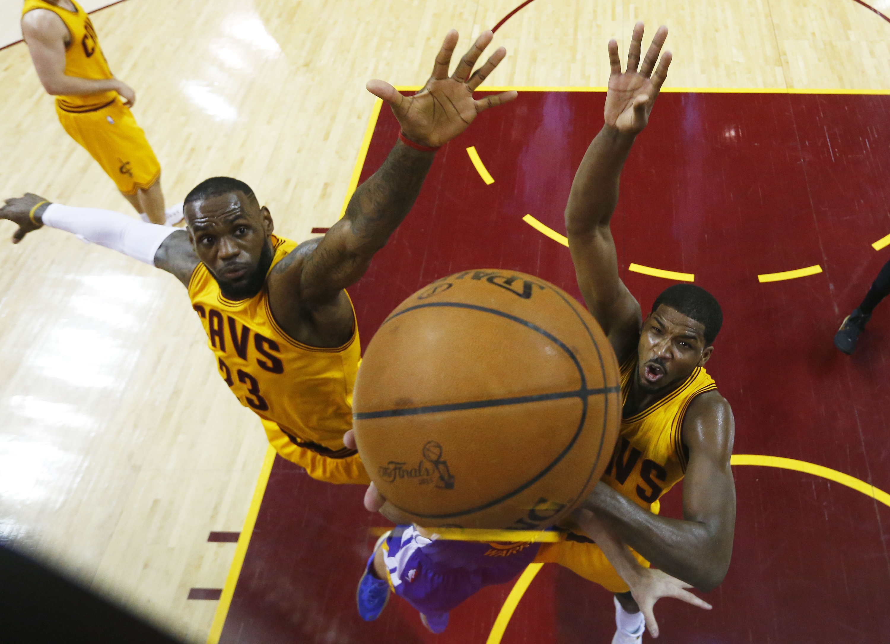 LeBron James and Tristan Thompson reach for a common goal. (Larry W. Smith-Pool/Getty Images)