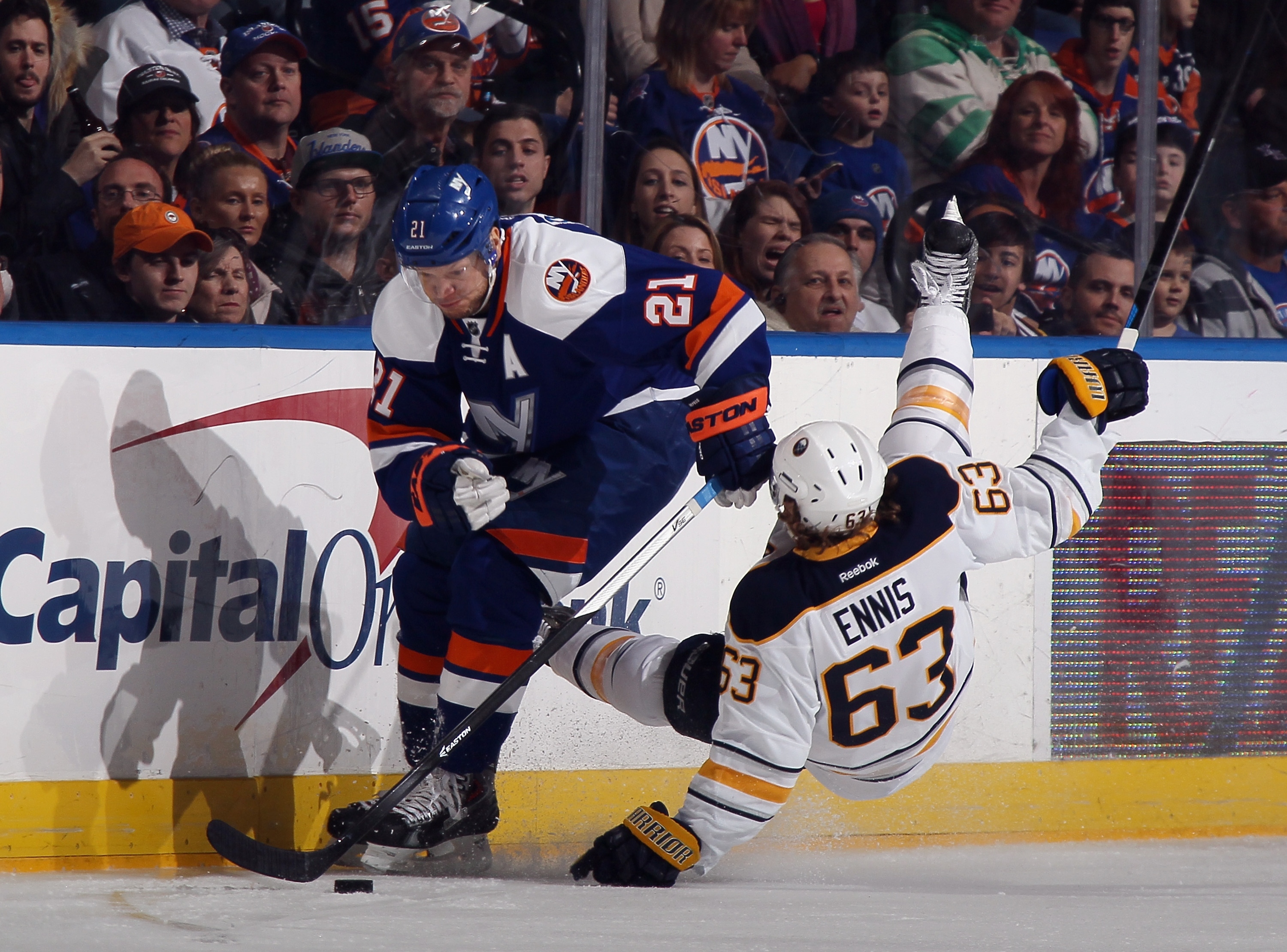 UNIONDALE, NY - APRIL 04: Tyler Ennis #63 of the Buffalo Sabres bounces off Kyle Okposo #21 of the New York Islanders during the first period at the Nassau Veterans Memorial Coliseum on April 4, 2015 in Uniondale, New York. (Photo by Bruce Bennett/Getty Images)