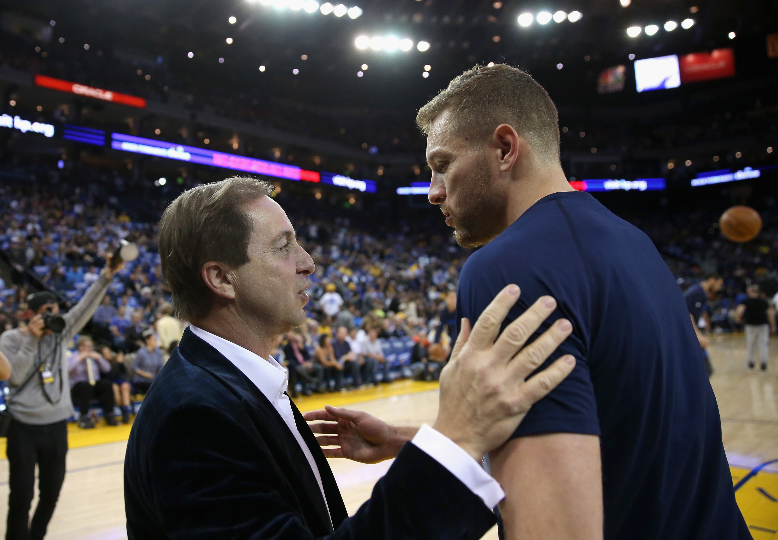 Joe Lacob speaks with David Lee, the first major free agent to join the Warriors during his tenure. (Ezra Shaw/Getty Images)