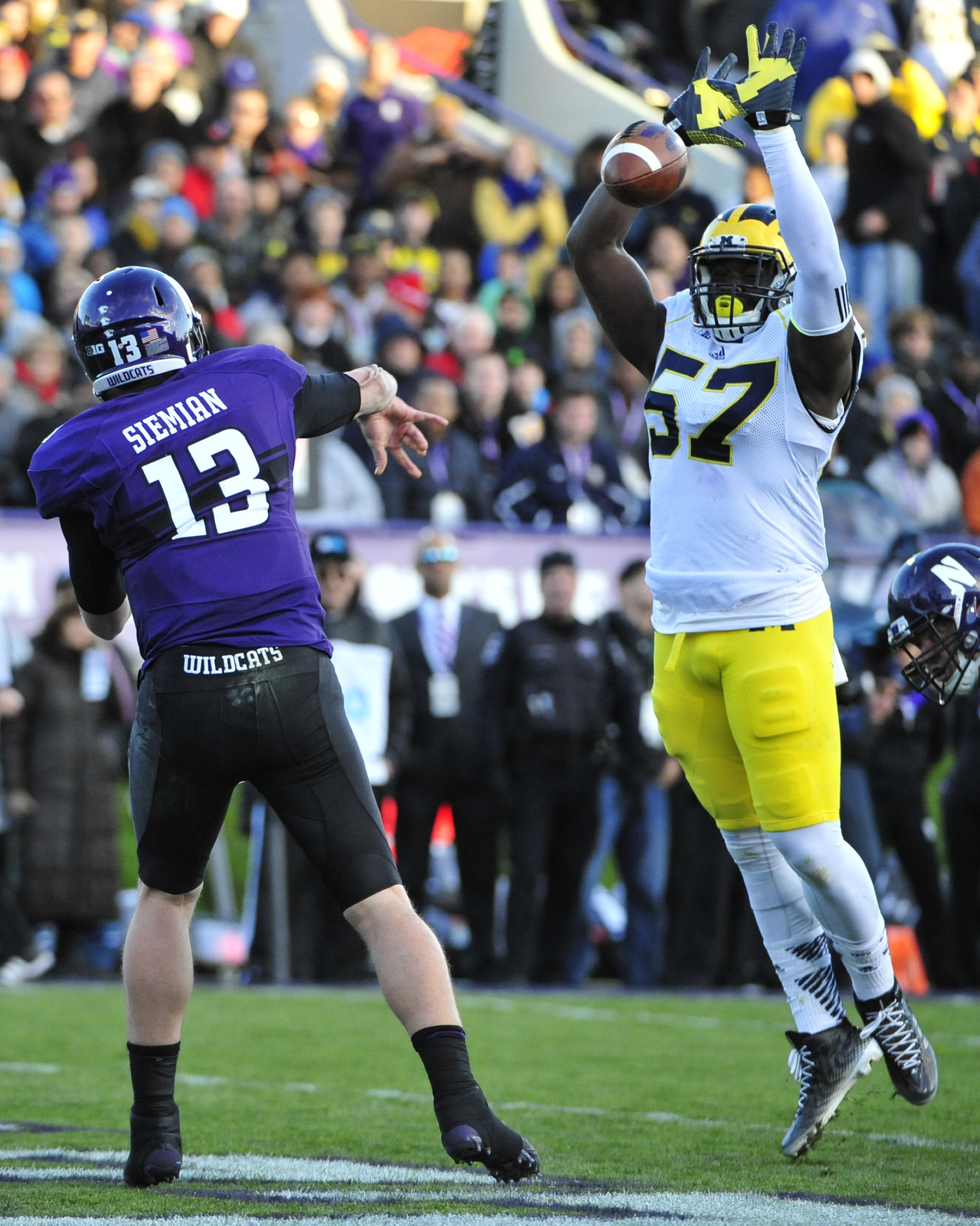 EVANSTON IL - NOVEMBER 08: Frank Clark #57 of the Michigan Wolverines blocks a pass by Trevor Siemian #13 of the Northwestern Wildcats during the first half on November 8, 2014 at Ryan Field in Evanston, Illinois.  (Photo by David Banks/Getty Images)