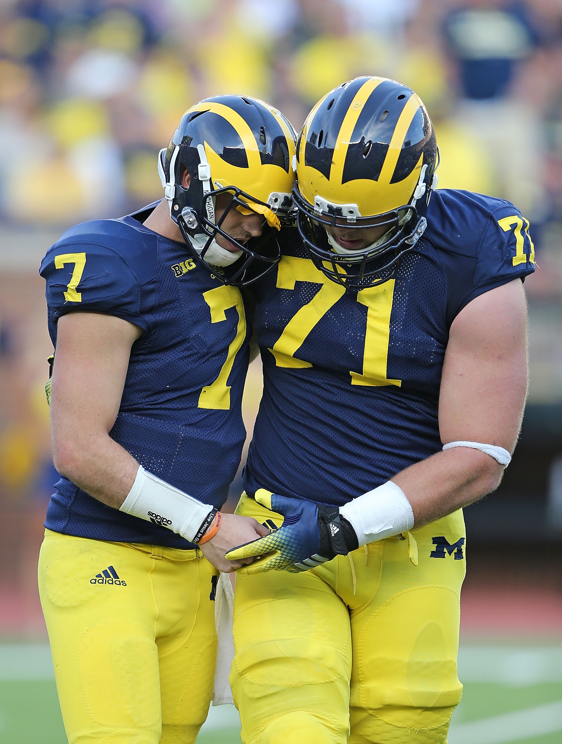 ANN ARBOR, MI - SEPTEMBER 27: Quarterback Shane Morris #7 of the Michigan Wolverines is helped off the field by Ben Braden #71 during the fourth quarter of the game against the Minnesota Golden Gophers at Michigan Stadium on September 27, 2014 in Ann Arbor, Michigan. The Golden Gophers defeated the Wolverines 30-14. (Photo by Leon Halip/Getty Images)