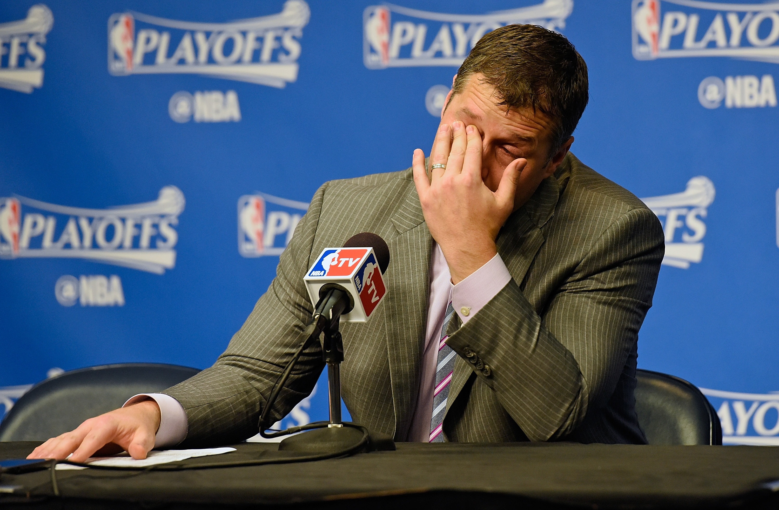 Grizzlies coach Dave Joerger wipes his eyes during the post game press conference. (Frederick Breedon/Getty Images)