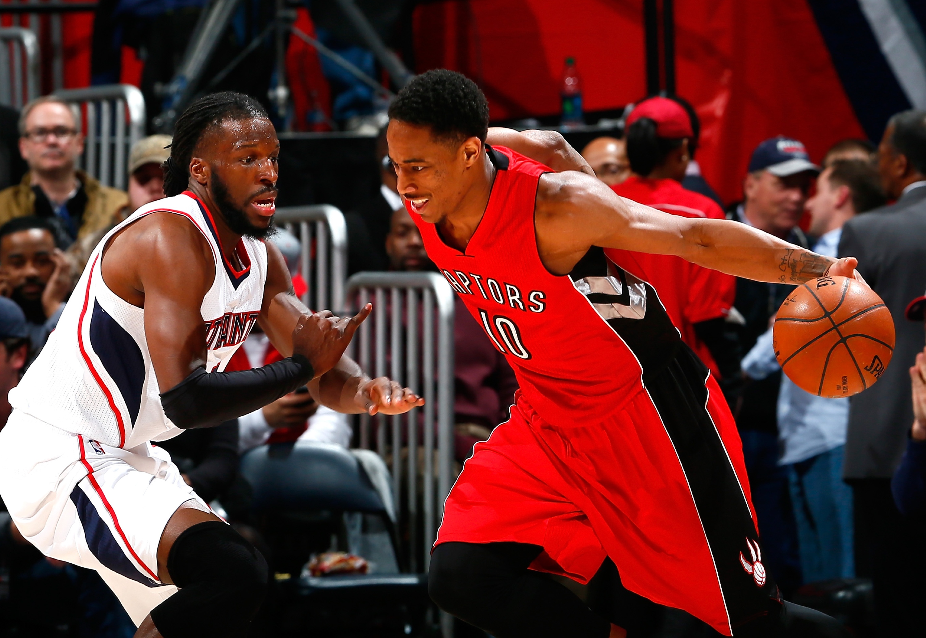 ATLANTA, GA - FEBRUARY 20:  DeMar DeRozan #10 of the Toronto Raptors drives against DeMarre Carroll #5 of the Atlanta Hawks at Philips Arena on February 20, 2015 in Atlanta, Georgia.  NOTE TO USER: User expressly acknowledges and agrees that, by downloading and or using this photograph, User is consenting to the terms and conditions of the Getty Images License Agreement.  (Photo by Kevin C. Cox/Getty Images)