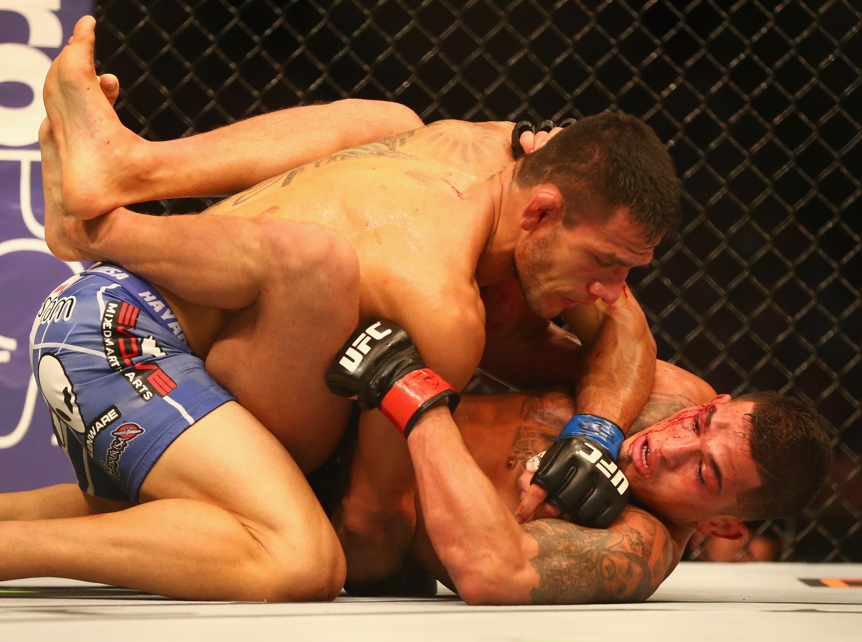Rafael dos Anjos drops an elbow on Anthony Pettis Saturday en route to winning the lightweight title in the main event of UFC 185 in Dallas.  (Photo by Ronald Martinez/Getty Images)