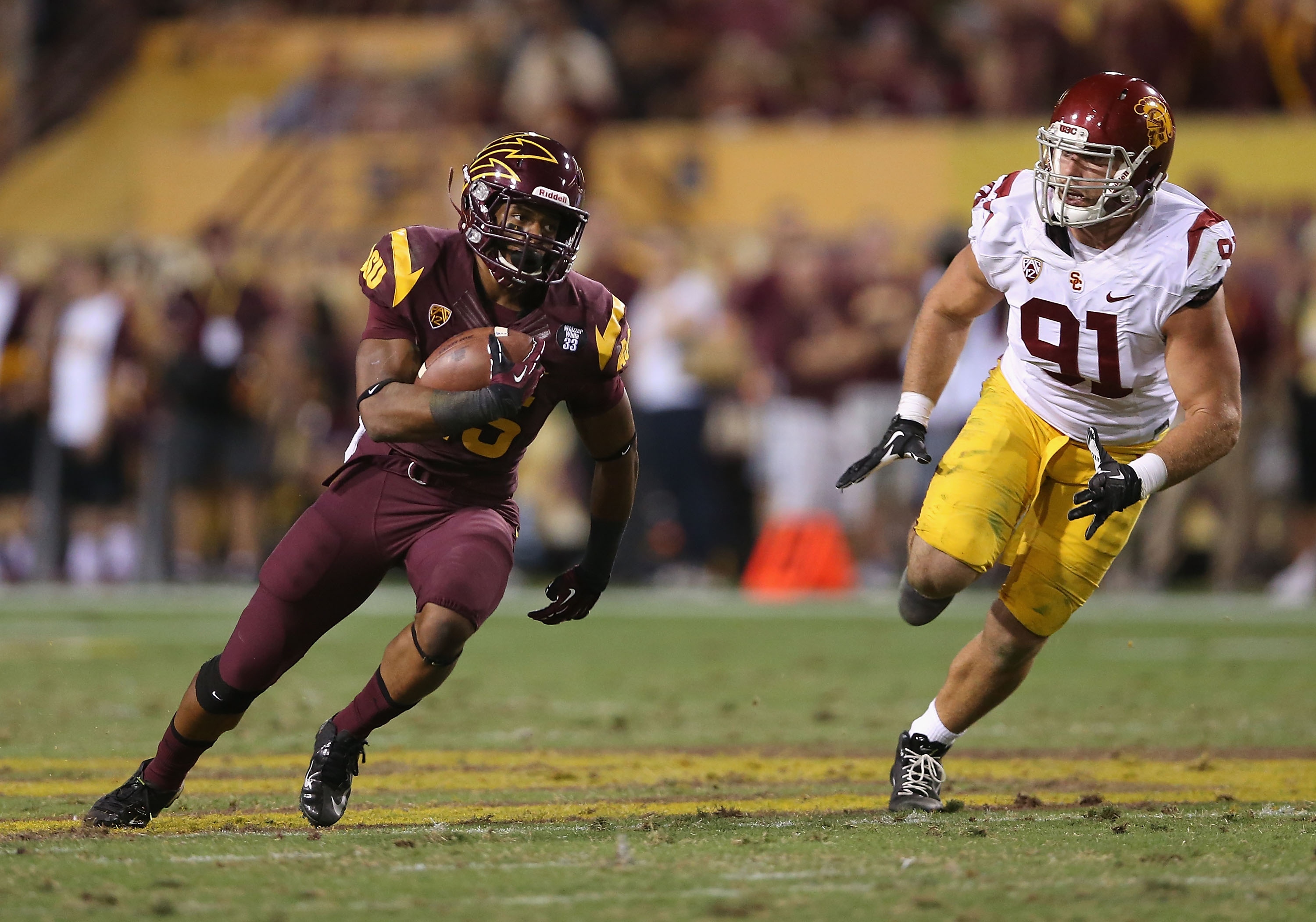 TEMPE, AZ - SEPTEMBER 28: Running back Deantre Lewis #25 of the Arizona State Sun Devils rushes the football for 45 yards past linebacker Morgan Breslin #91 of the USC Trojans during the fourth quarter of the college football game at Sun Devil Stadium on September 28, 2013 in Tempe, Arizona. The Sun Devils defeated the Trojans 62-41. (Photo by Christian Petersen/Getty Images)