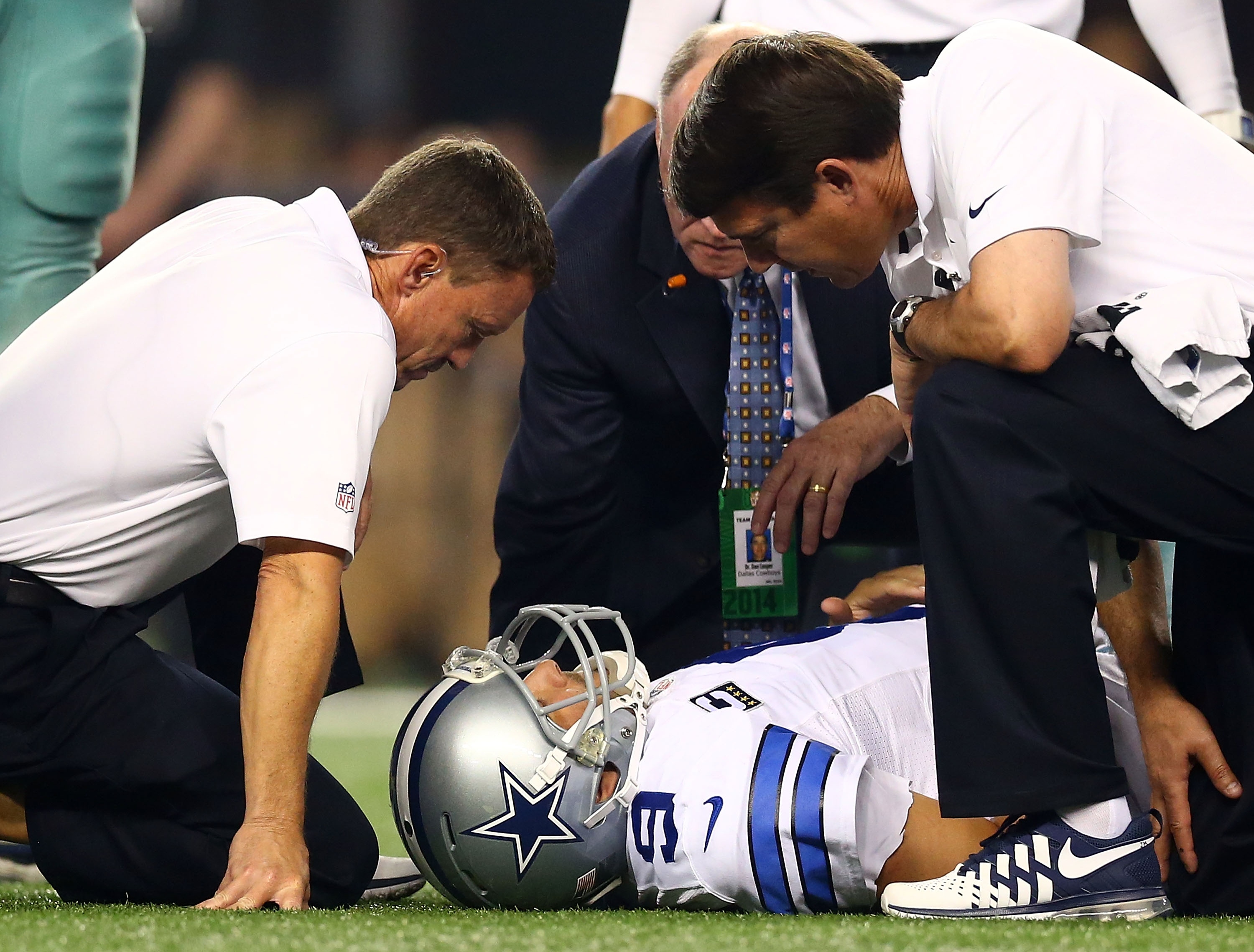 ARLINGTON, TX - OCTOBER 27: Tony Romo #9 of the Dallas Cowboys is attended to by team personnel after being sacked by Keenan Robinson #52 of the Washington Redskins during the second half at AT&T Stadium on October 27, 2014 in Arlington, Texas. (Photo by Ronald Martinez/Getty Images)