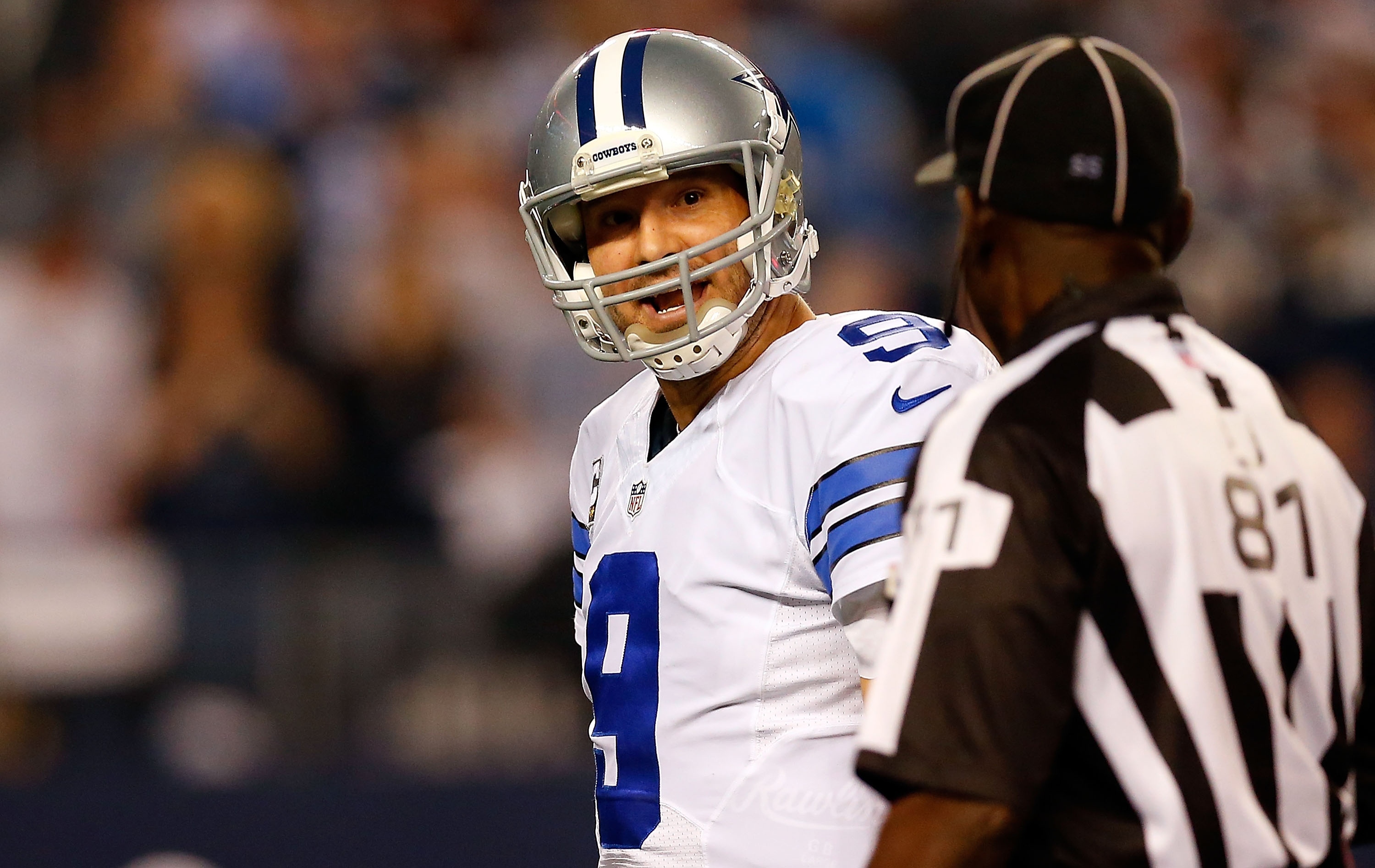 Tony Romo chats with a referee. (Photo by Tom Pennington/Getty Images)