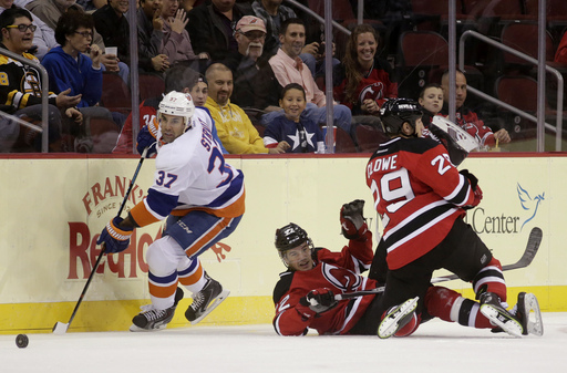 New Jersey Devils left wing Ryane Clowe (29) collides with teammate defenseman Eric Gelinas, center, as New York Islanders defenseman Brian Strait (37) skates with the puck during the first period of an NHL preseason hockey game, Thursday, Oct. 2, 2014, in Newark, N.J. (AP Photo/Julio Cortez)