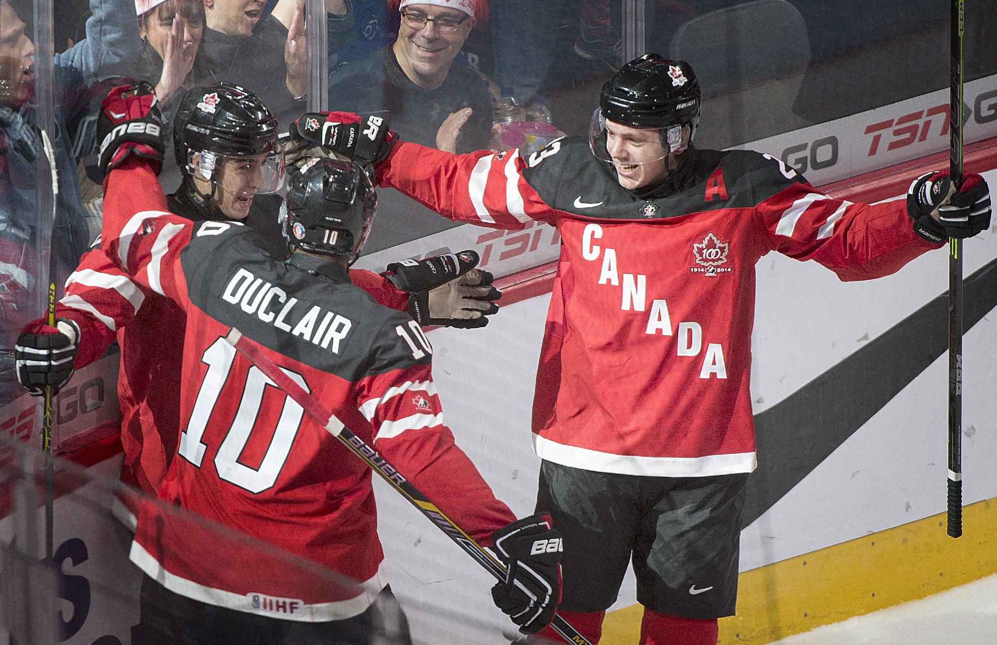 Canada's Robby Fabbri, left, celebrates with teammates Anthony Duclair and Sam Reinhart, right, after scoring against Slovakia during the first period of a round-robin game at the hockey World Junior Championship, Friday, Dec. 26, 2014, in Montreal. (AP Photo/The Canadian Press, Graham Hughes)