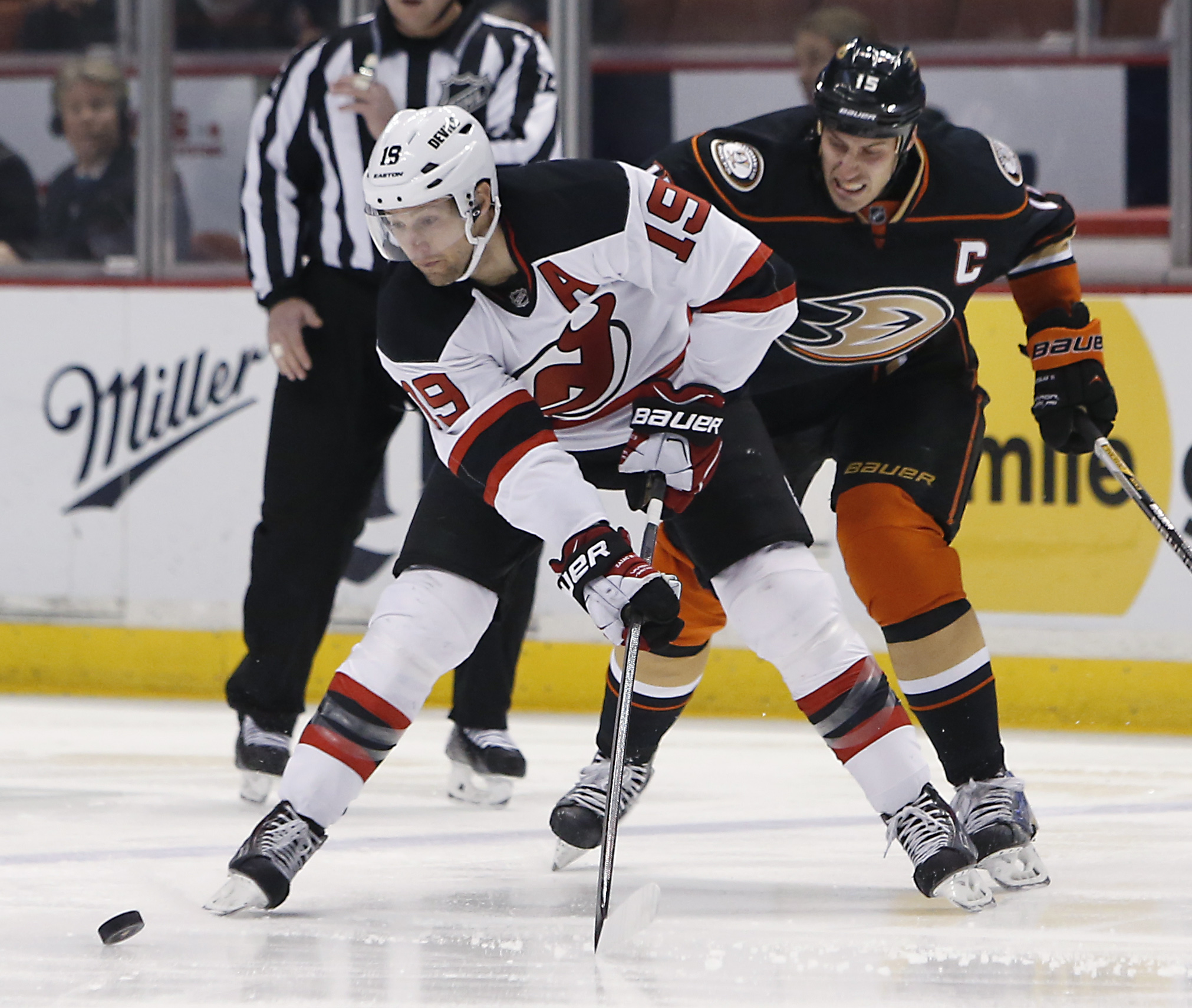 Anaheim Ducks' Ryan Getzlaf (15) and New Jersey Devils' Travis Zajac (19) vie for the puck during the first period of an NHL hockey game, Friday, Jan. 16, 2015, in Anaheim, Calif. (AP Photo/Christine Cotter)