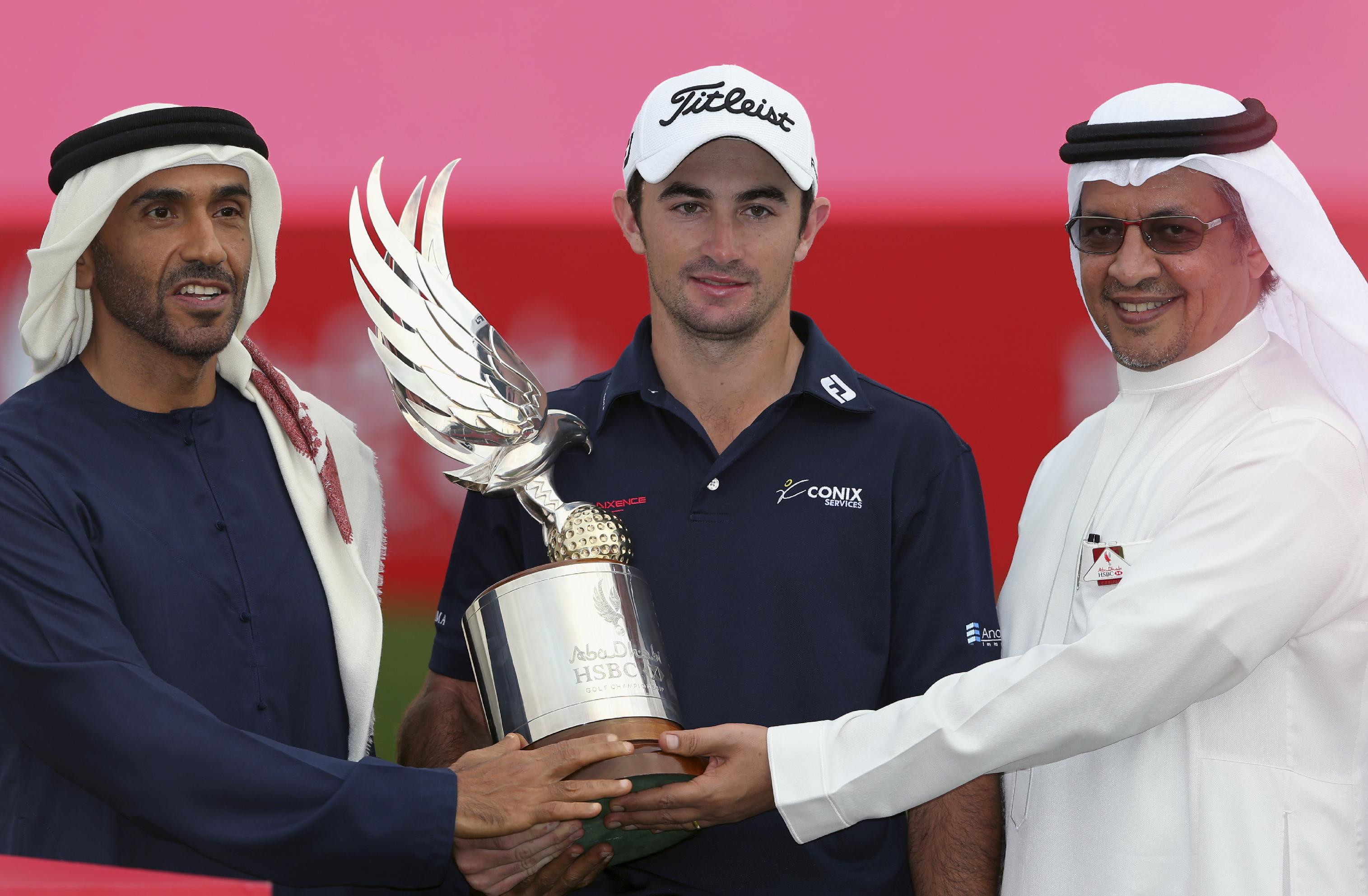 Gary Stal of France, center, receives the trophy from Sheikh Nahyan Bin Zayed Al Nahyan, chairman of the Abu Dhabi Sports Council, left, and Mohammad Al-Tuwaijri, chief executive of HSBC Middle East and North Africa, after Stal wins the HSBC Golf Championship in Abu Dhabi, United Arab Emirates, Sunday, Jan. 18, 2015. (AP Photo/Kamran Jebreili)