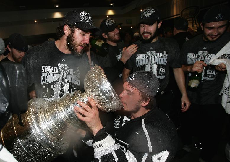 FILE - In this June 11, 2012, file photo, Los Angeles Kings' Mike Richards, Andrei Loktionov, Jonathan Quick and Drew Doughty celebrate with the Stanley Cup in the locker room after the Kings defeated the New Jersey Devils in game six of the NHL hockey Stanley Cup finals in Los Angeles. The Kings released Richards on Monday, Jan. 26, 2015, finally shaking up their relationship with the veteran center who has lost his scoring touch. (AP Photo/Dave Sandford, Pool, File)