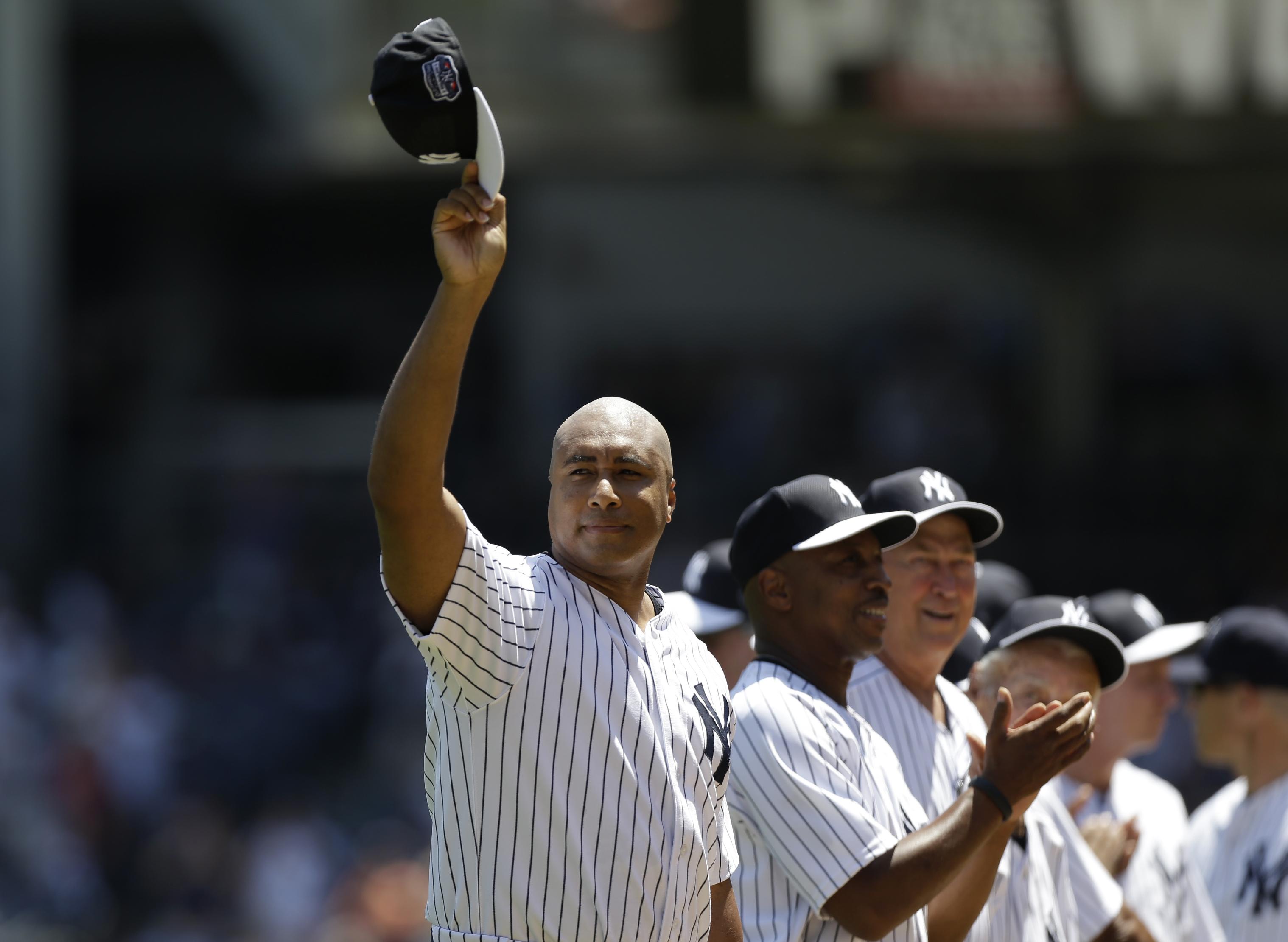 Bernie Williams waving his cap as he is introduced before the Yankees Old Timers Day baseball game in 2012. (AP)