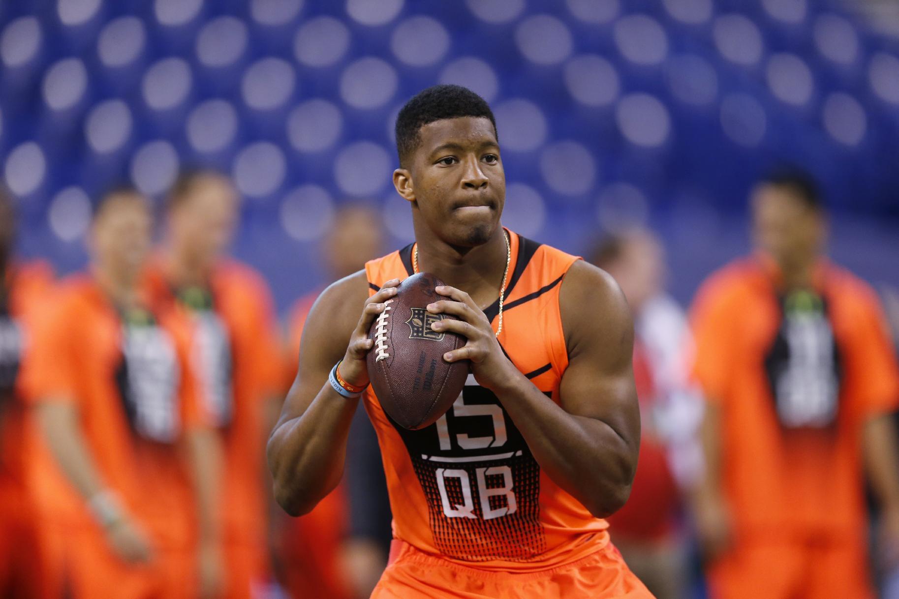 FILE - In this Feb. 21, 2015, file photo, Florida State quarterback Jameis Winston runs a drill at the NFL football scouting combine in Indianapolis. While 26 draft-eligible players have accepted invitations from the NFL to attend the proceedings later this month, Winston and Marcus Mariota are not among them. The two most recent Heisman Trophy winners and highest-profile players in this year's crop have opted to stay home with their families for the April 30-May 2 draft. (AP Photo/Julio Cortez, File)