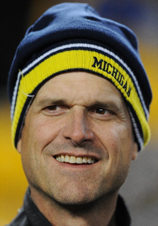 FILE- In this file photo from Jan. 3, 2015, The new Michigan football coach, Jim Harbaugh, is on the sideline before an NFL wildcard playoff football game in Pittsburgh. The pundits are talking up the Big Ten league this spring, largely because of the achievements and trend lines in the East Division. There was Ohio State's national championship under Urban Meyer, Michigan State's bowl win over a Baylor team that narrowly missed the College Football Playoff, Jim Harbaugh's hiring at Michigan and Penn State's rebuilding job under James Franklin. (AP Photo/Don Wright, file)