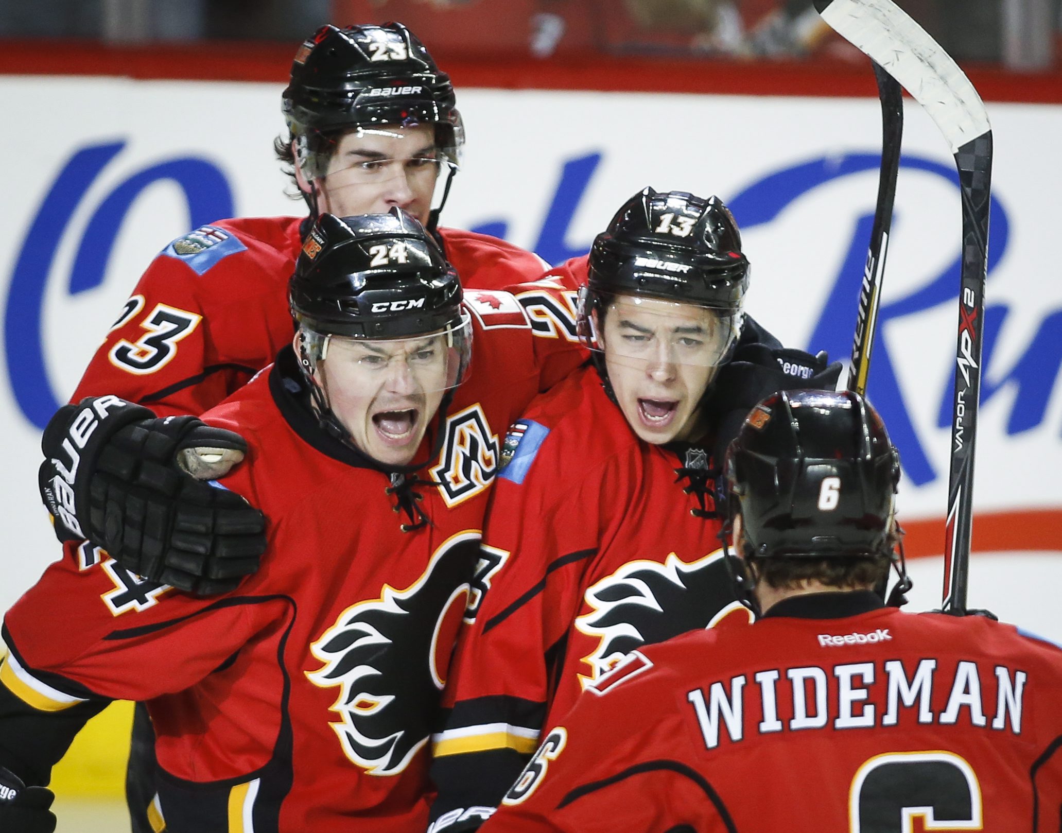 Calgary Flames' Johnny Gaudreau, center right, celebrates his goal with against the Vancouver Canucks with teammates Sean Monahan, left, Jiri Hudler, center left, from the Czech Republic and Dennis Wideman during the first period of Game 4 of a first-round NHL hockey playoff series, Tuesday, April 21, 2015, in Calgary, Alberta. (Jeff McIntosh/The Canadian Press via AP)