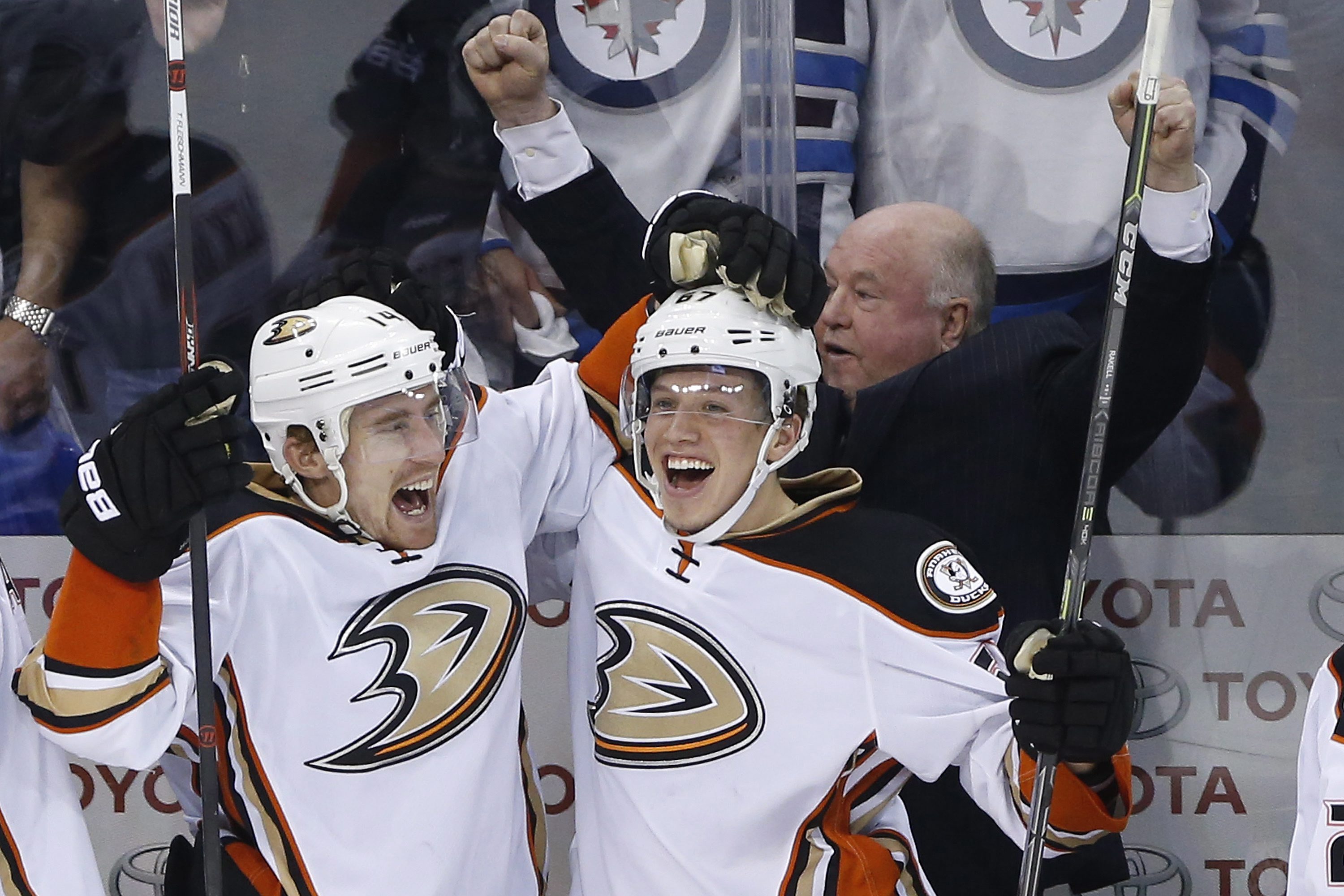 Anaheim Ducks' Tomas Fleischmann (14), Rickard Rakell (67) and coach Bruce Boudreau celebrate a goal against the Winnipeg Jets during the third period of Game 4 of a first-round NHL hockey playoff series, Wednesday, April 22, 2015, in Winnipeg, Manitoba. Anaheim won 5-2 and swept the series. (John Woods/The Canadian Press via AP)