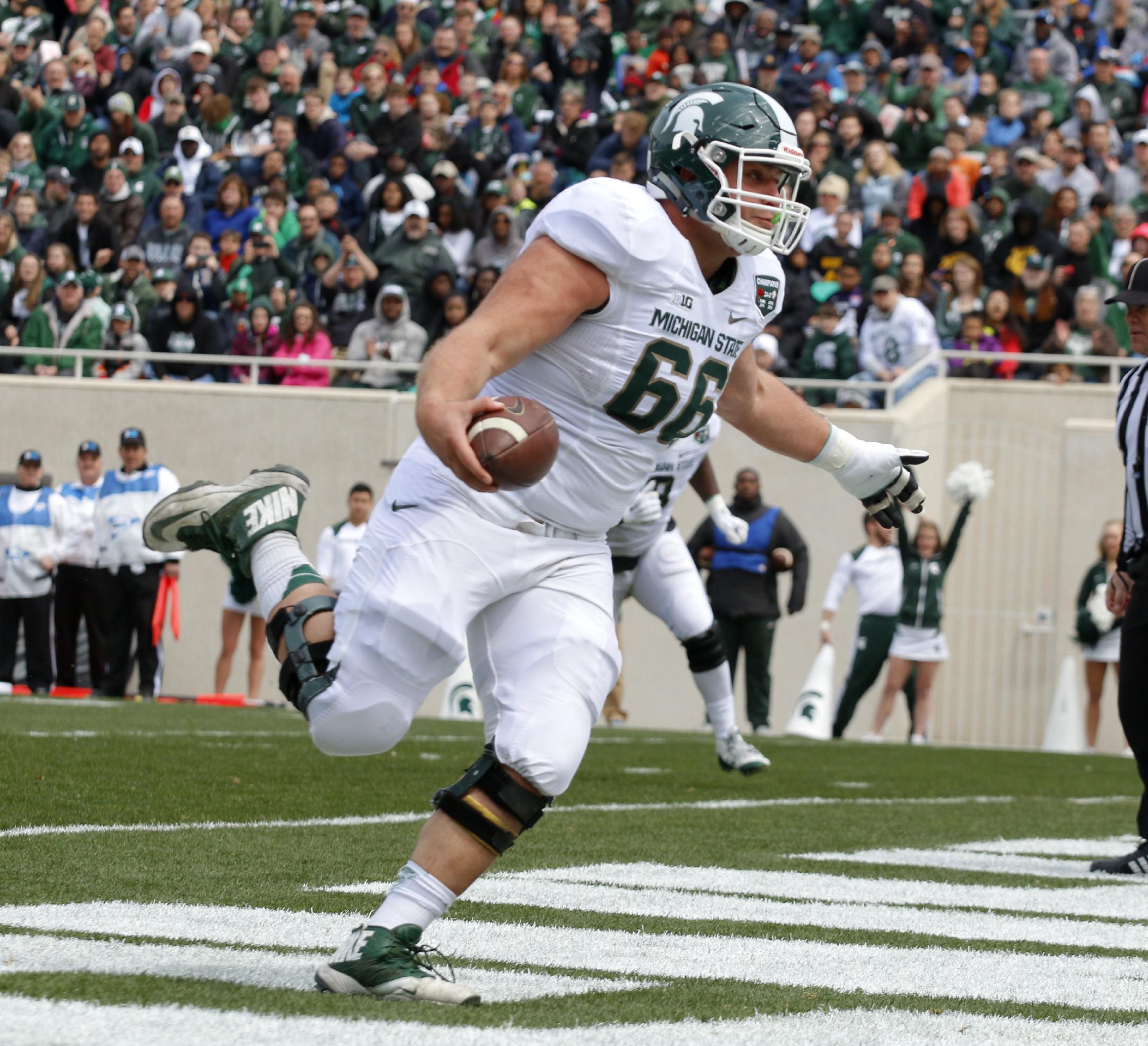 Michigan State White team offensive lineman Jack Allen scores a rushing touchdown during the Spartans' spring NCAA college football game, Saturday, April 25, 2015, in East Lansing, Mich. The White team won 9-3. (AP Photo/Al Goldis)