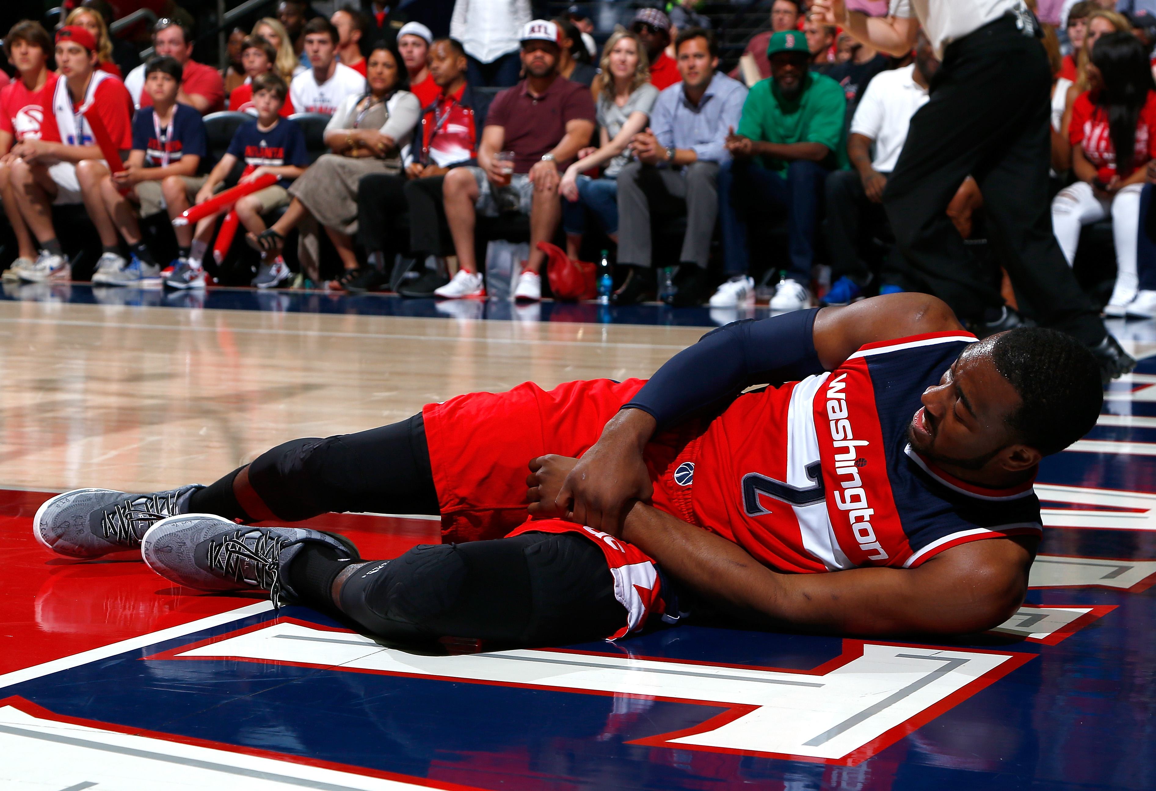 John Wall grabs his wrist after hitting the floor in Game 1. (Kevin C. Cox/Getty Images)