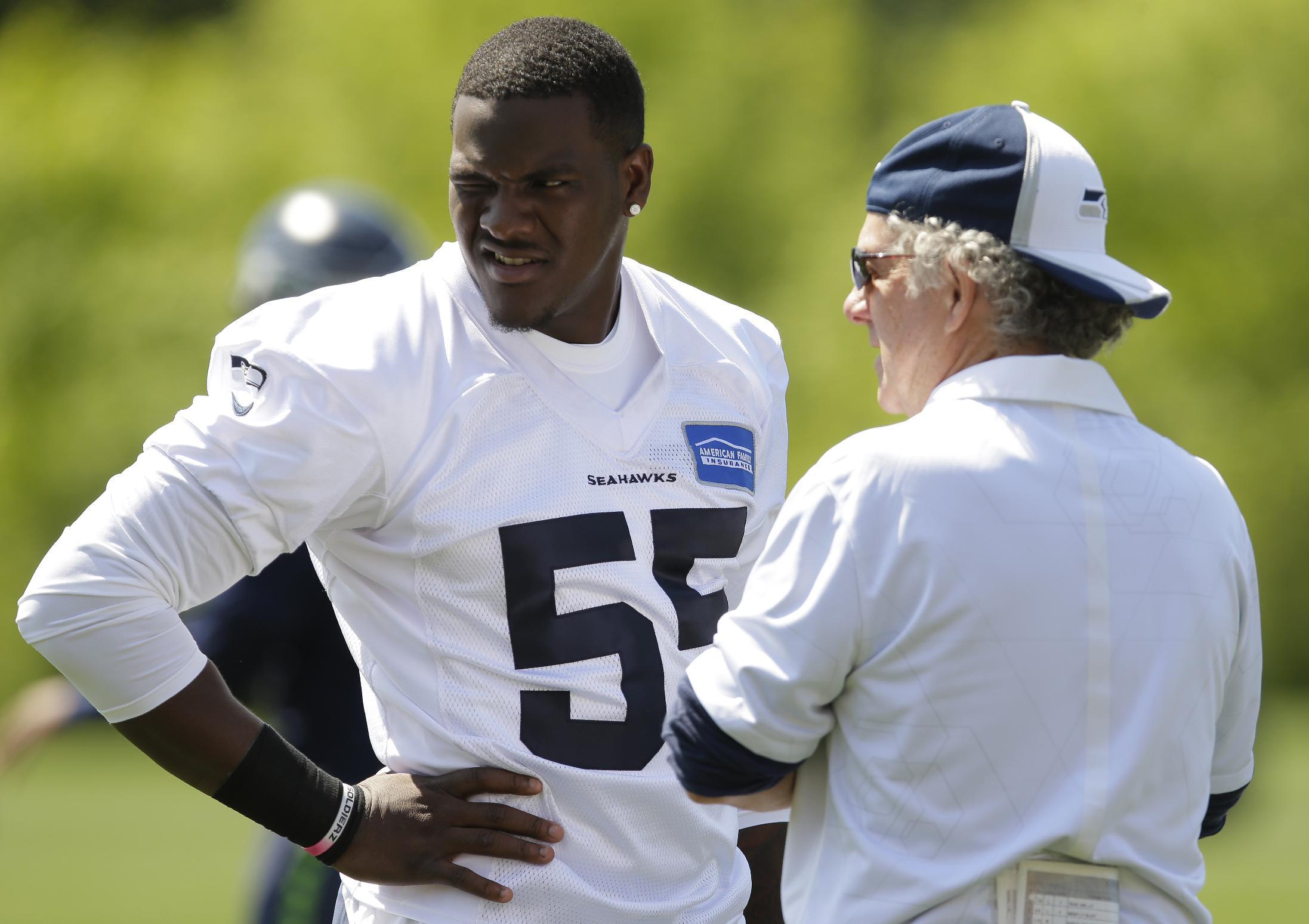 Seattle Seahawks rookie defensive end Frank Clark (55) talks with quarterbacks coach Carl Smith, right, during NFL football rookie minicamp, Friday, May 8, 2015, in Renton, Wash. (AP Photo/Ted S. Warren)