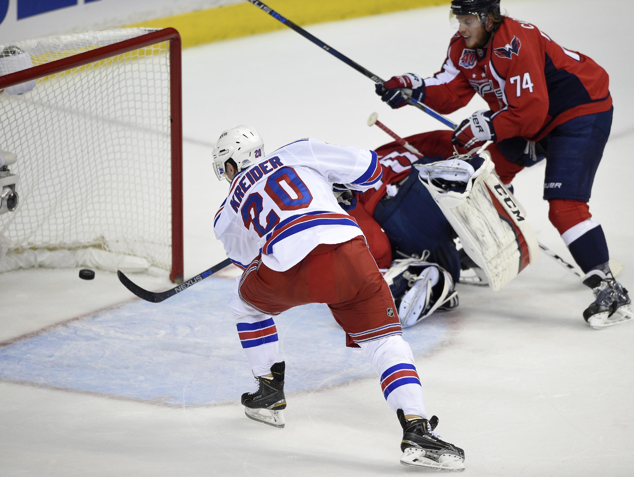 New York Rangers left wing Chris Kreider (20) scores his second goal of the period during the first period past Washington Capitals goalie Braden Holtby (70), center, and John Carlson (74) in Game 6 in the second round of the NHL Stanley Cup hockey playoffs, Sunday, May 10, 2015, in Washington. (AP Photo/Nick Wass)